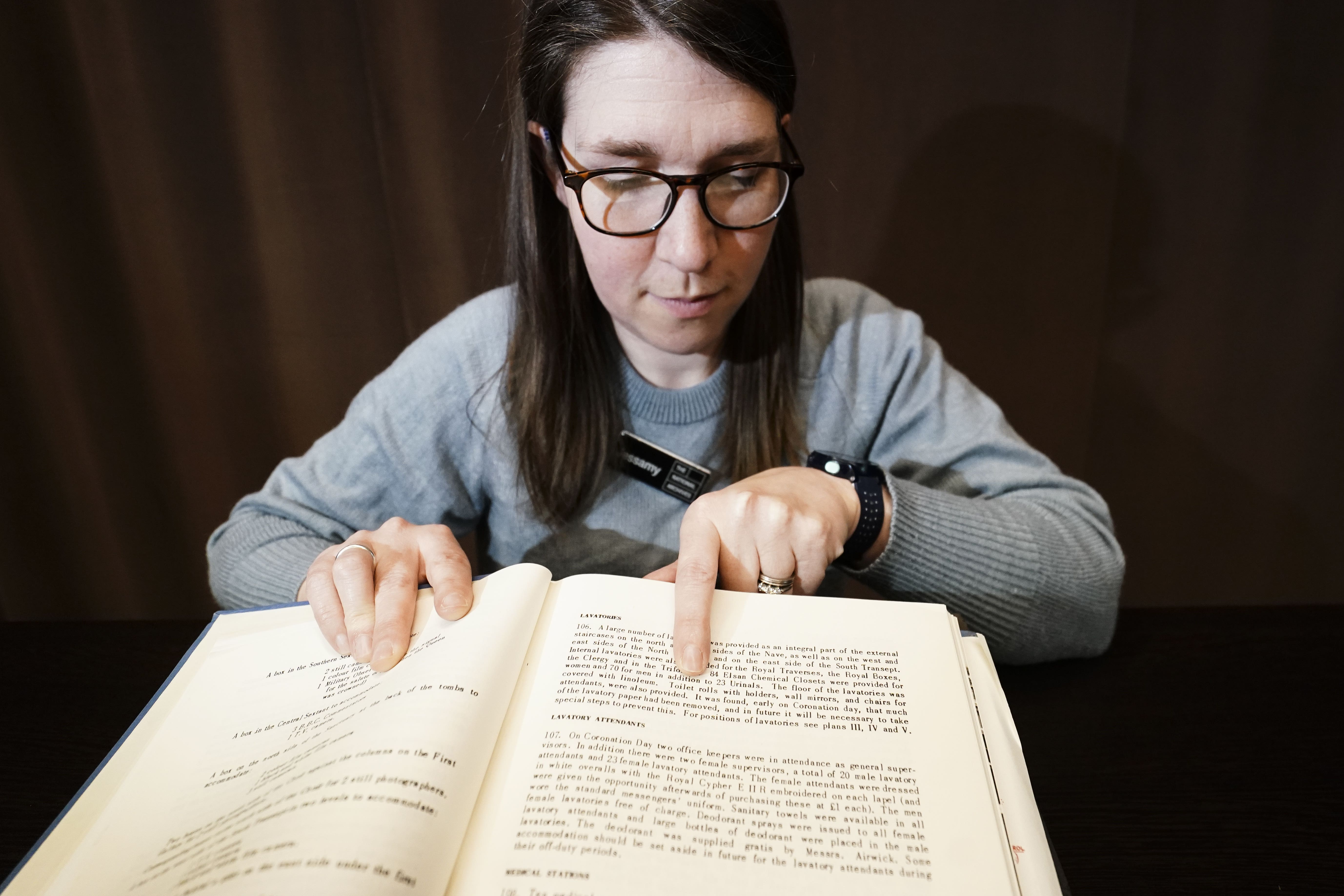 Jessamy Carlson, record specialist at The National Archives, looks at a paragraph detailing toilet arrangements for the coronation of Queen Elizabeth II at the National Archives in Kew, Richmond, London (Jordan Pettitt/PA)