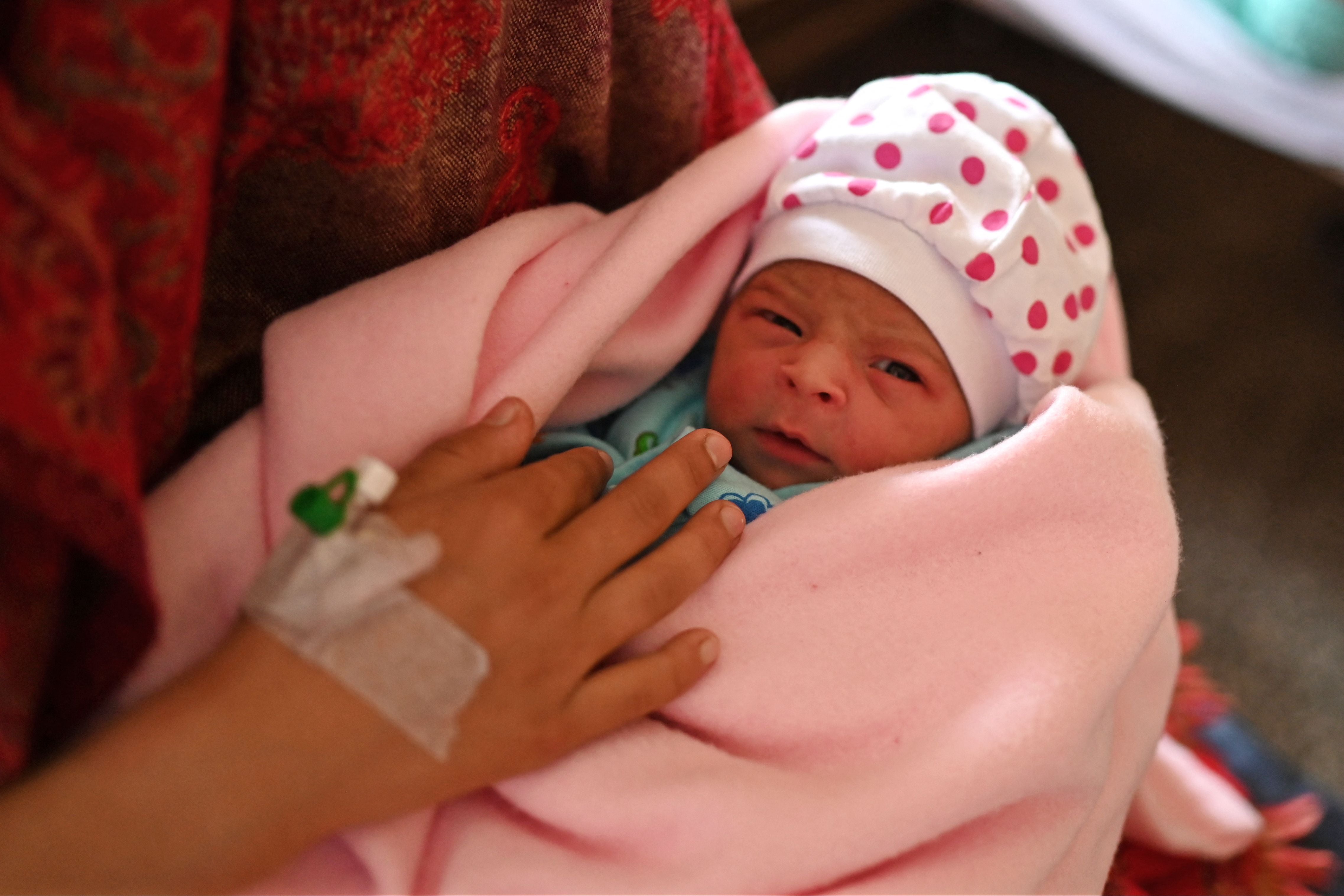 Manu Bala holding her newborn daughter on Tuesday