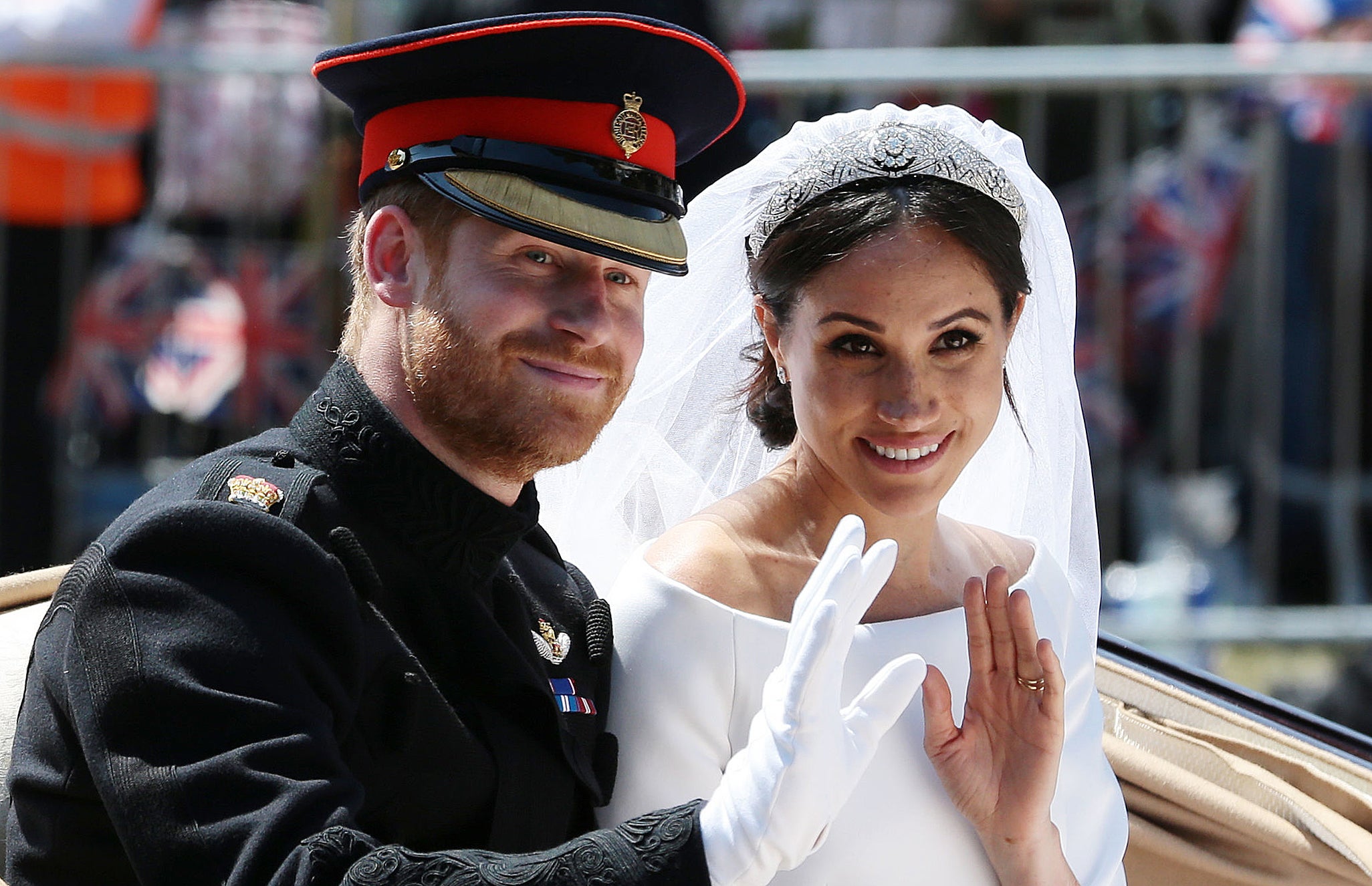 Prince Harry, Duke of Sussex and his wife Meghan, Duchess of Sussex wave from the Ascot Landau Carriage during their carriage procession on the Long Walk as they head back towards Windsor Castle in Windsor, on May 19, 2018