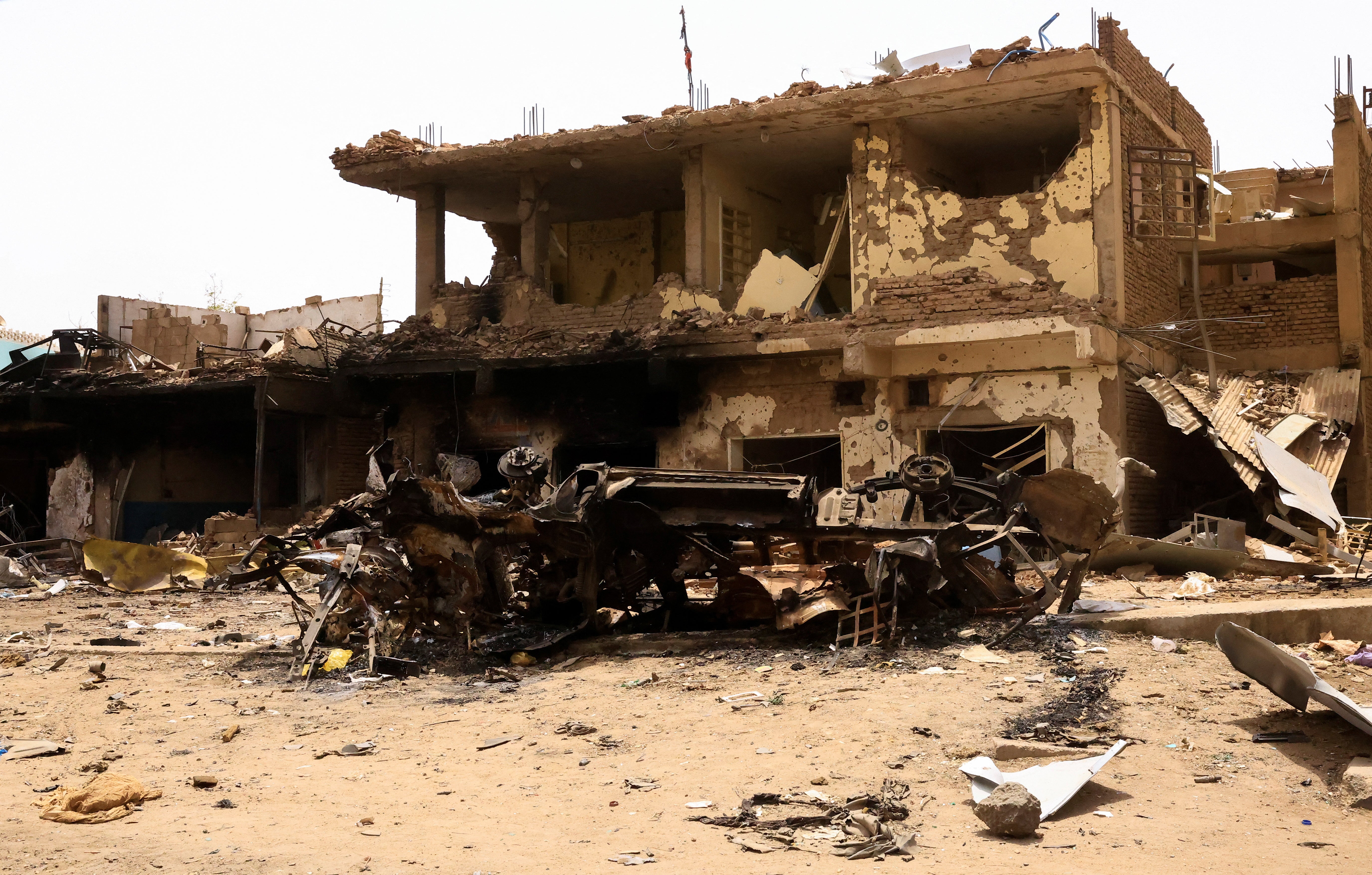 A damaged car and buildings are seen at the central market during clashes between the paramilitary Rapid Support Forces and the army in Khartoum