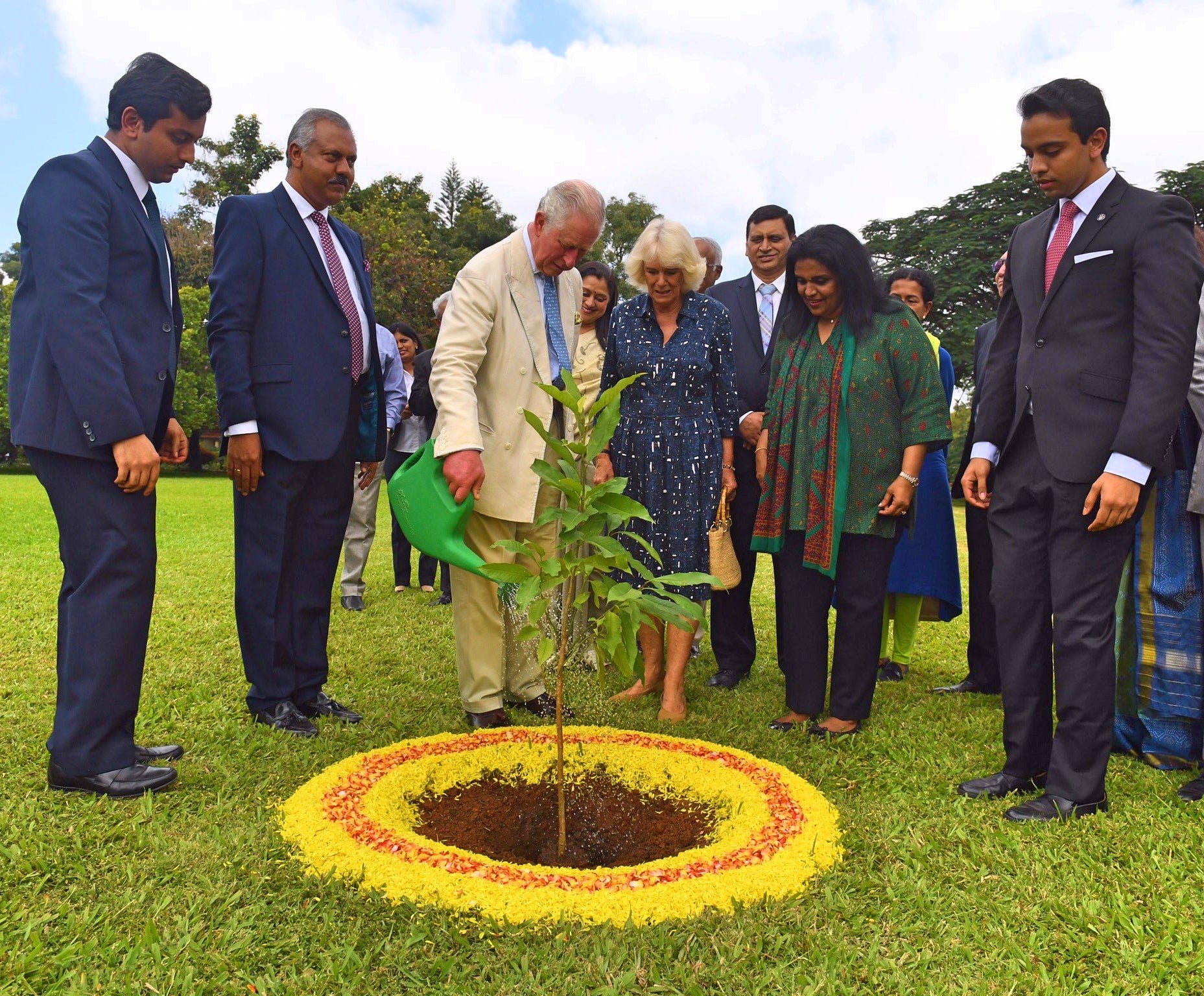 King Charles III planting a sapling at Soukya alongside the Queen as Dr Isaac Mathai, second from left, looks on