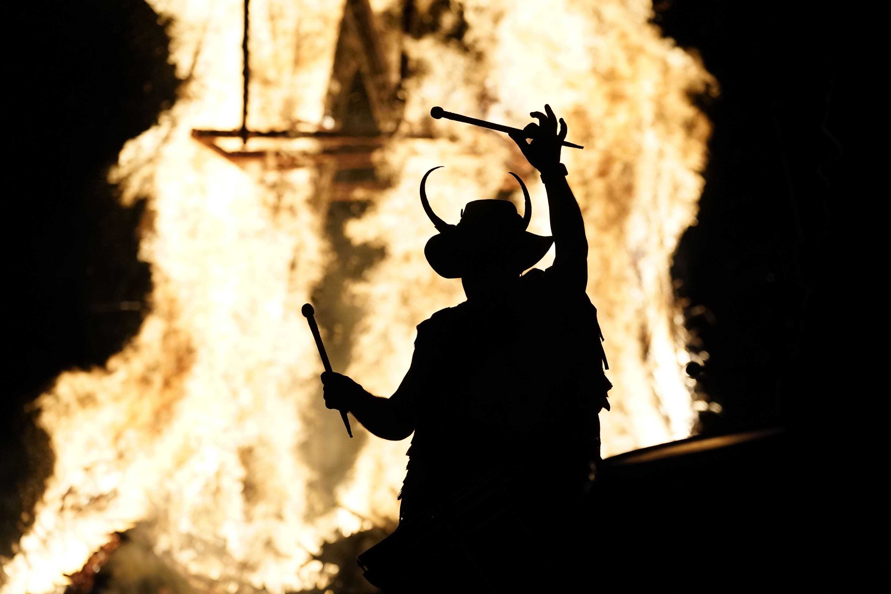 Members of the Pentacle Drummers perform in front of a burning wicker man during the Beltane Celtic Fire Festival at Butser Ancient Farm, in Waterlooville, Hampshire (Andrew Matthews/PA)