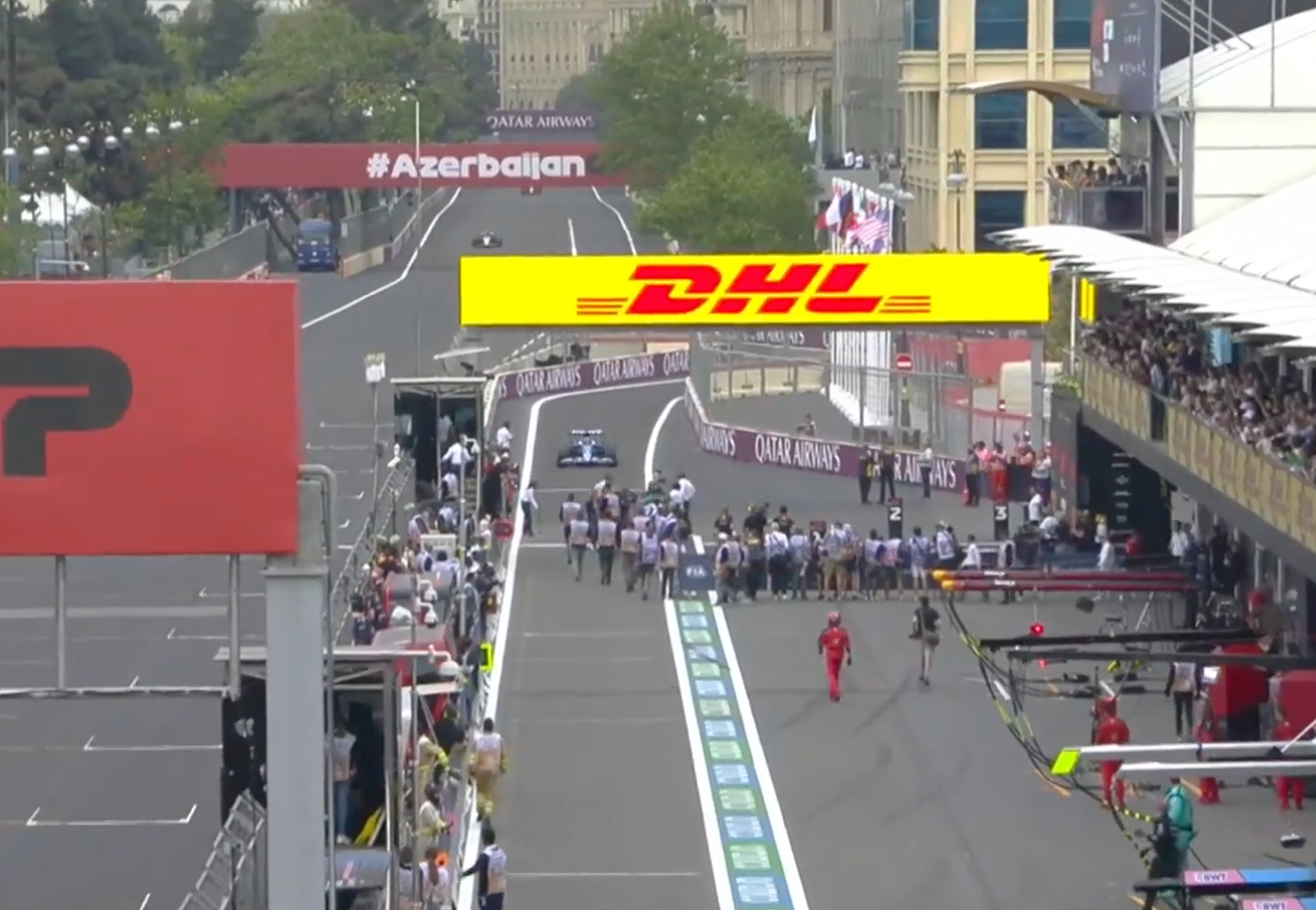 Esteban Ocon enters the pit lane and photographers leap out of the way