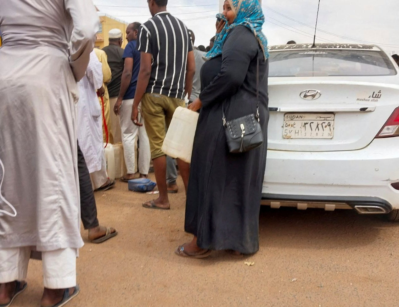 People gather to get fuel at a station, as clashes between the paramilitary Rapid Support Forces and the army continue, in south Khartoum