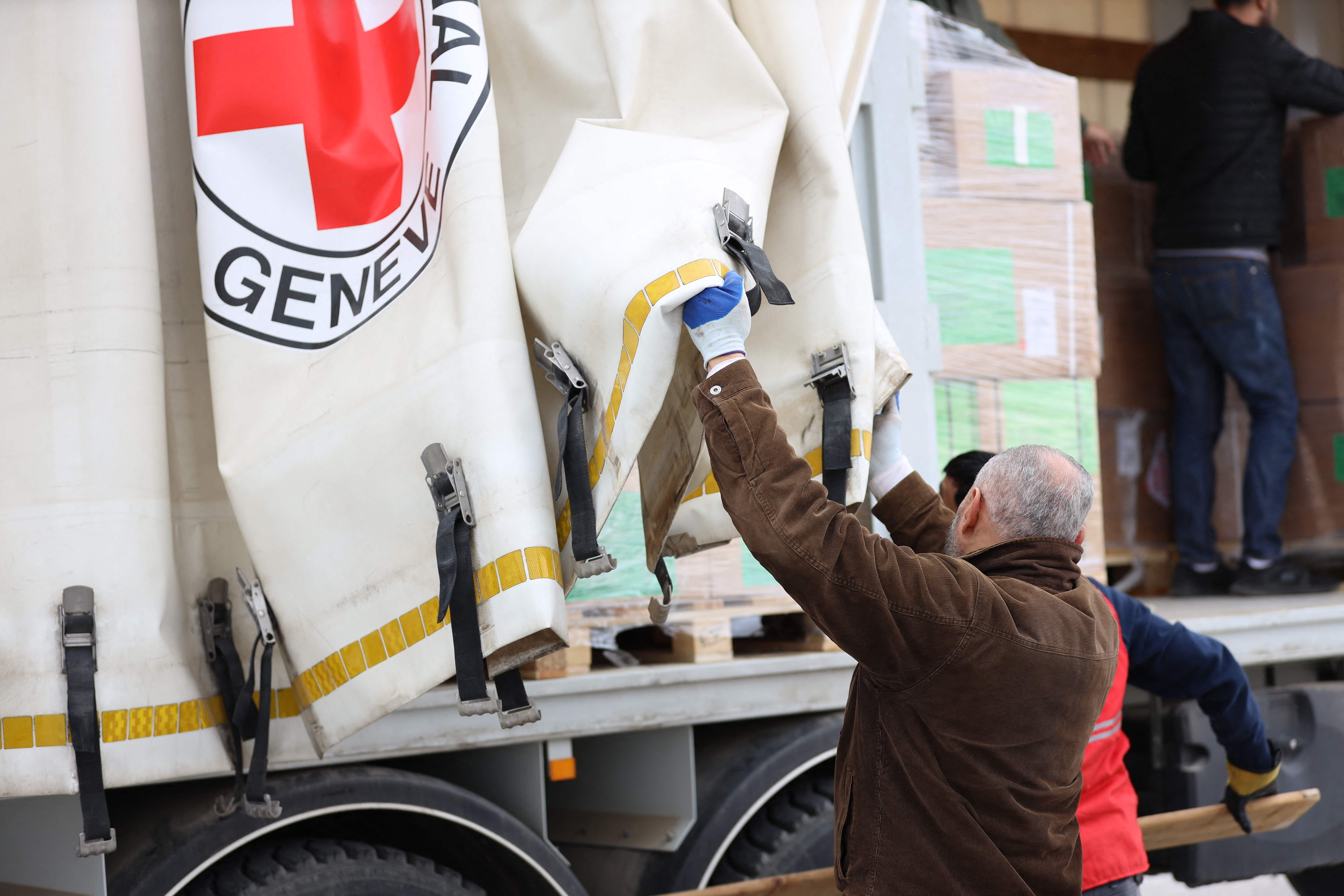 Members of the International Committee of the Red Cross prepare boxes of humanitarian aid in Amman