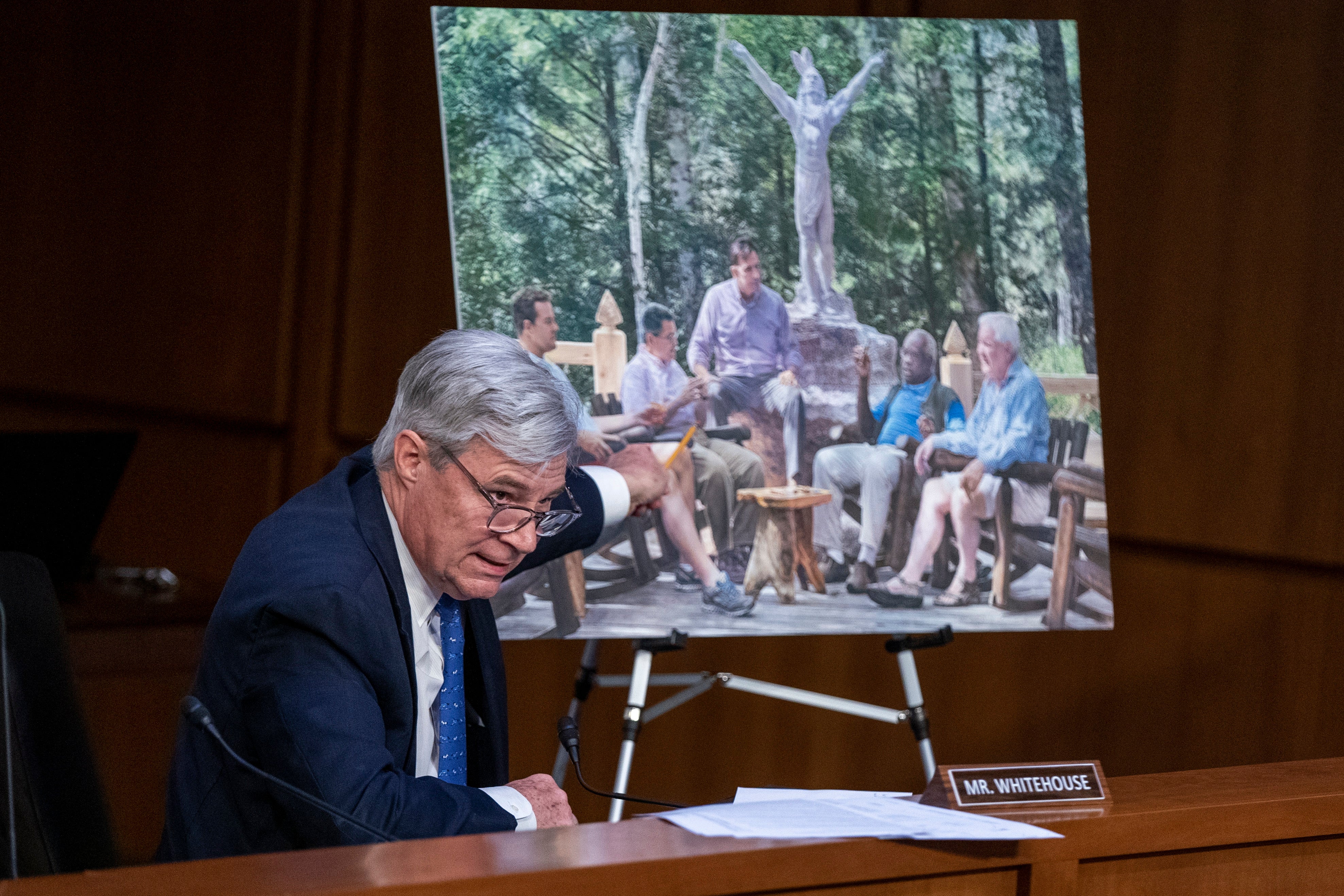 Senator Sheldon Whitehouse shows a photo-realistic painting of Clarence Thomas with influential right-wing figures that hangs inside a vacation home owned by a GOP megadonor.