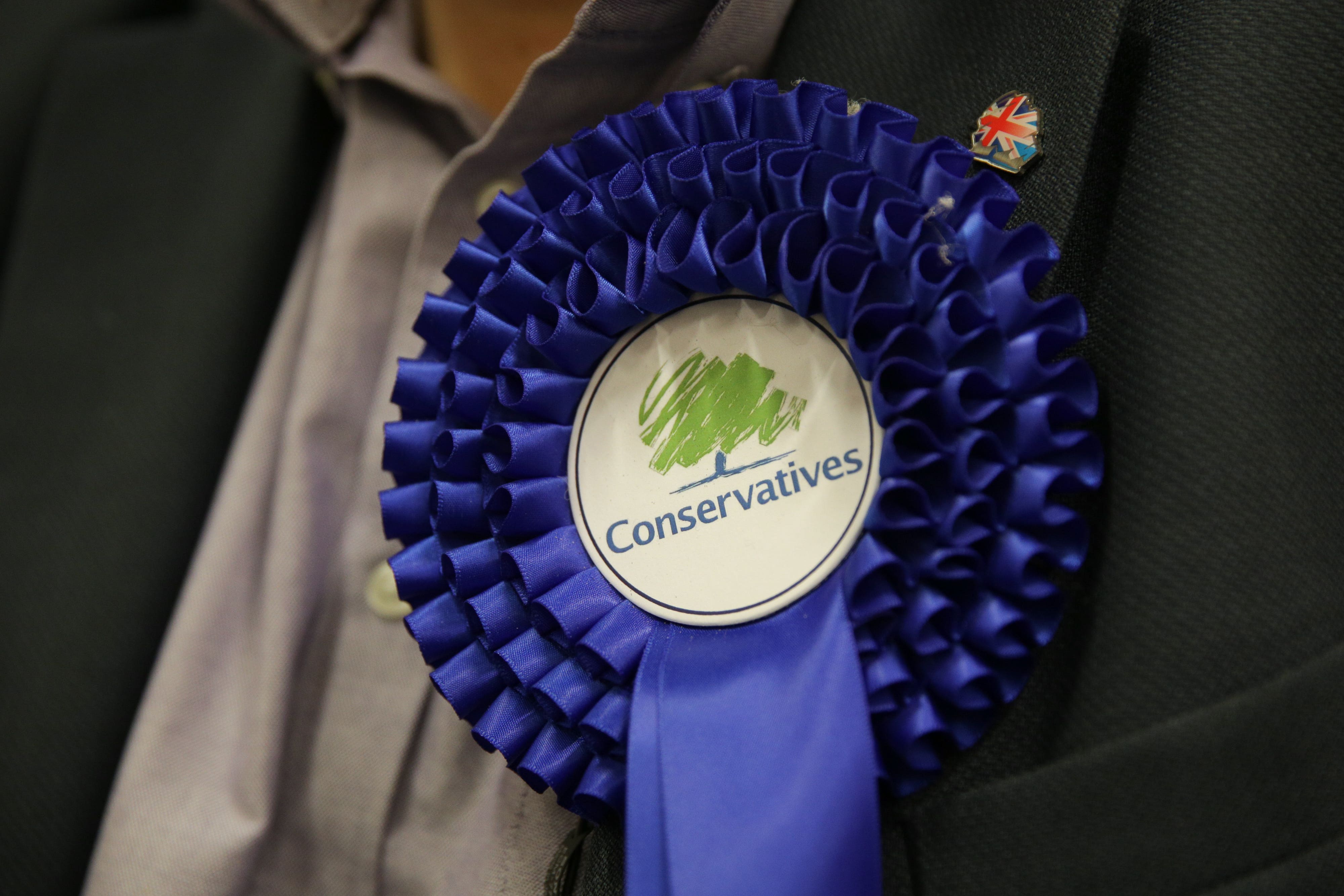 A Conservative rosette is worn (Daniel Leal-Olivas/PA)