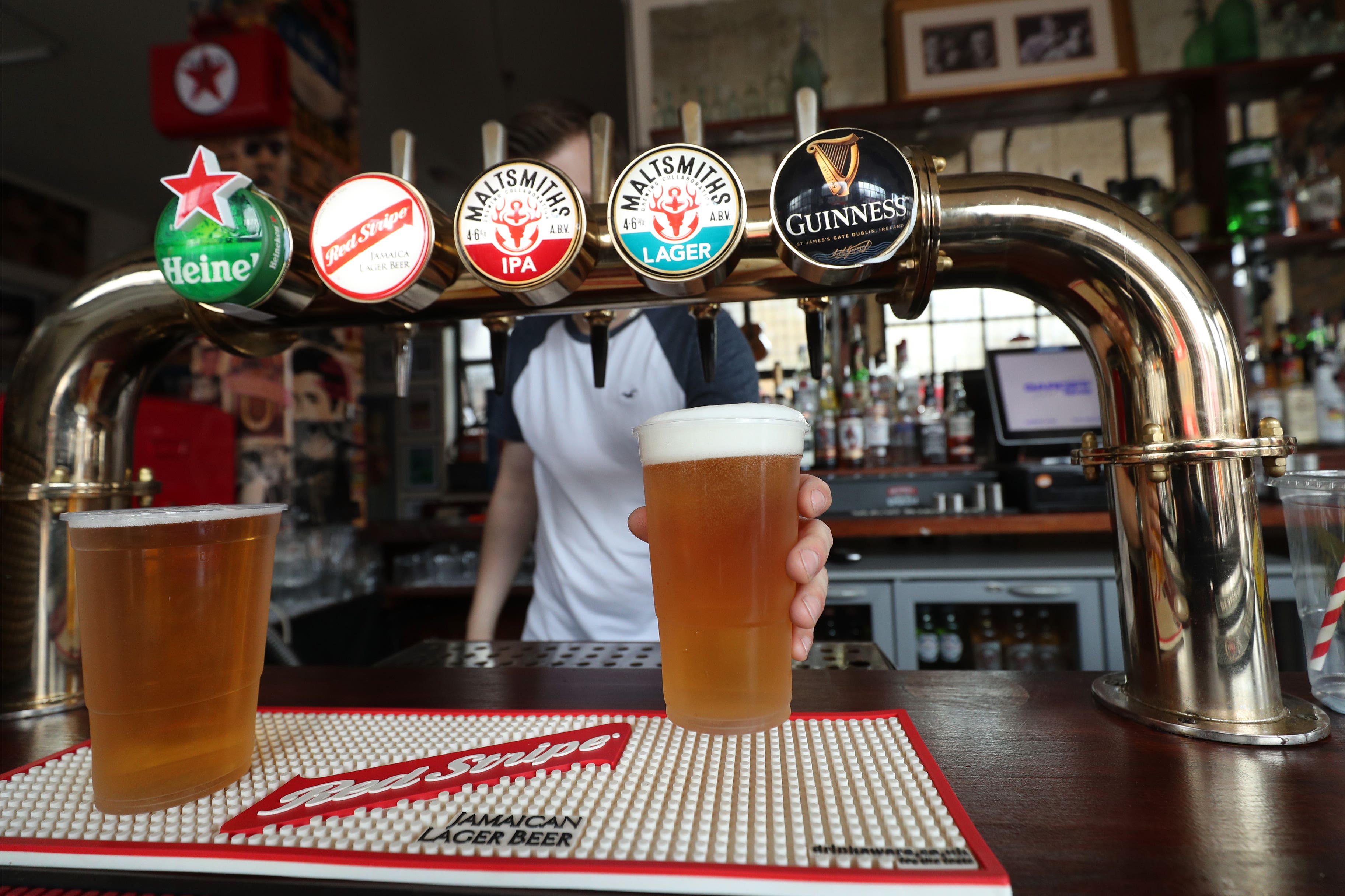 A barman serving takeaway drinks (Yui Mok/PA)