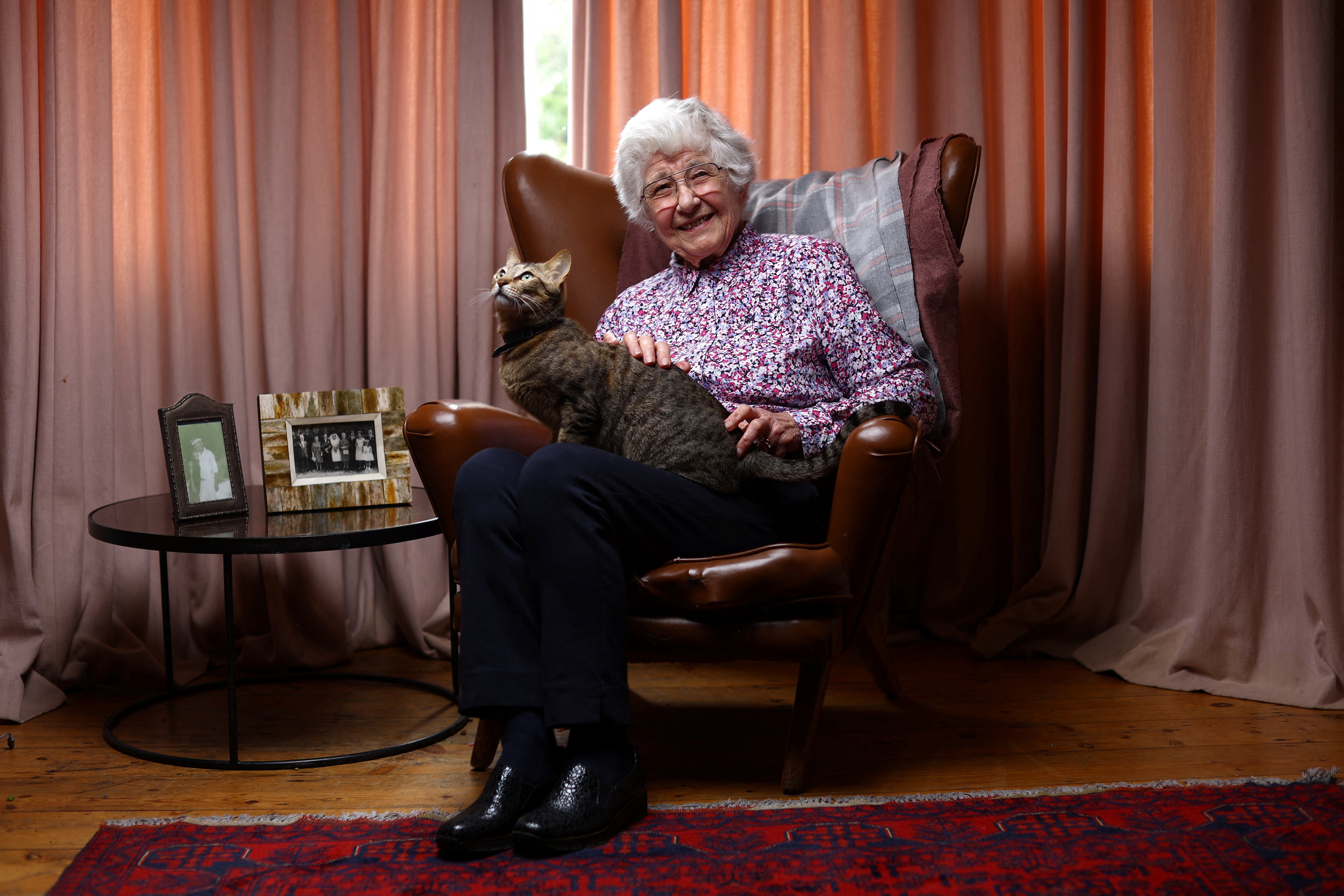 Brenda Piper, 88, poses for a photograph with her daughter's cat Bueno, in her daughter's home in London