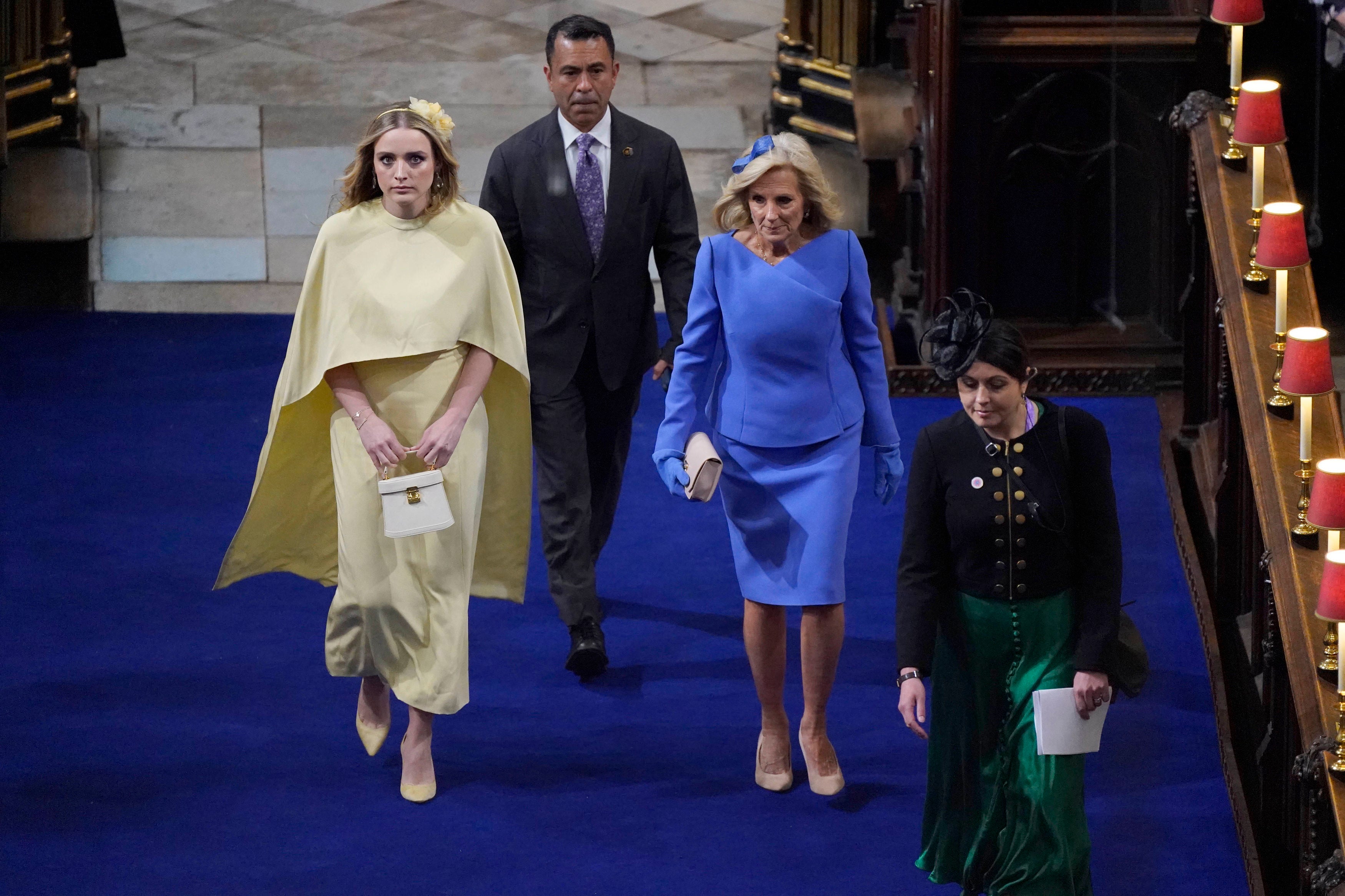 Jill Biden, dressed in blue, and her granddaughter Finnegan, walk up the church aisle