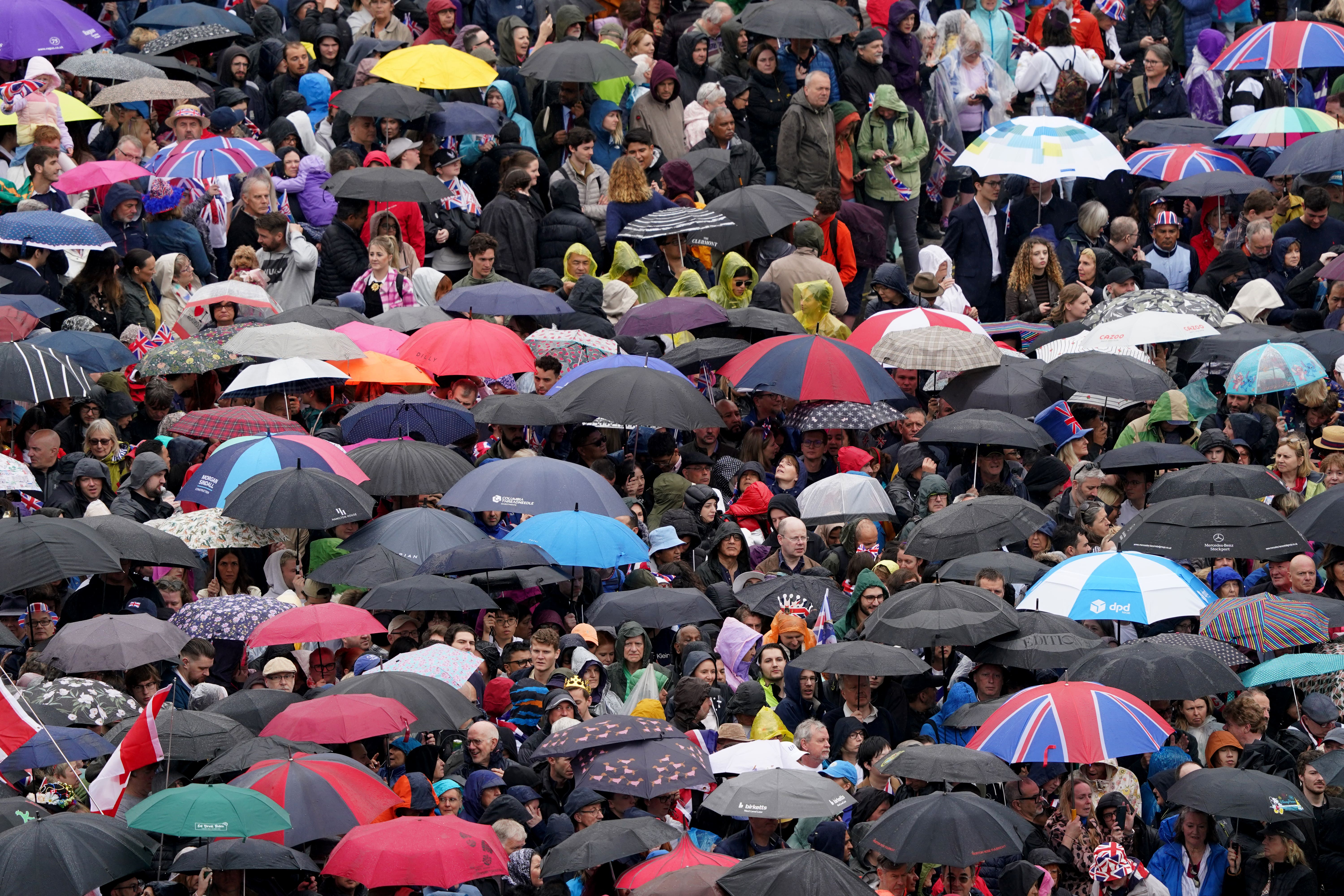 Crowds near Trafalgar Square take shelter from the rain ahead of the coronation ceremony of King Charles III and Queen Camilla