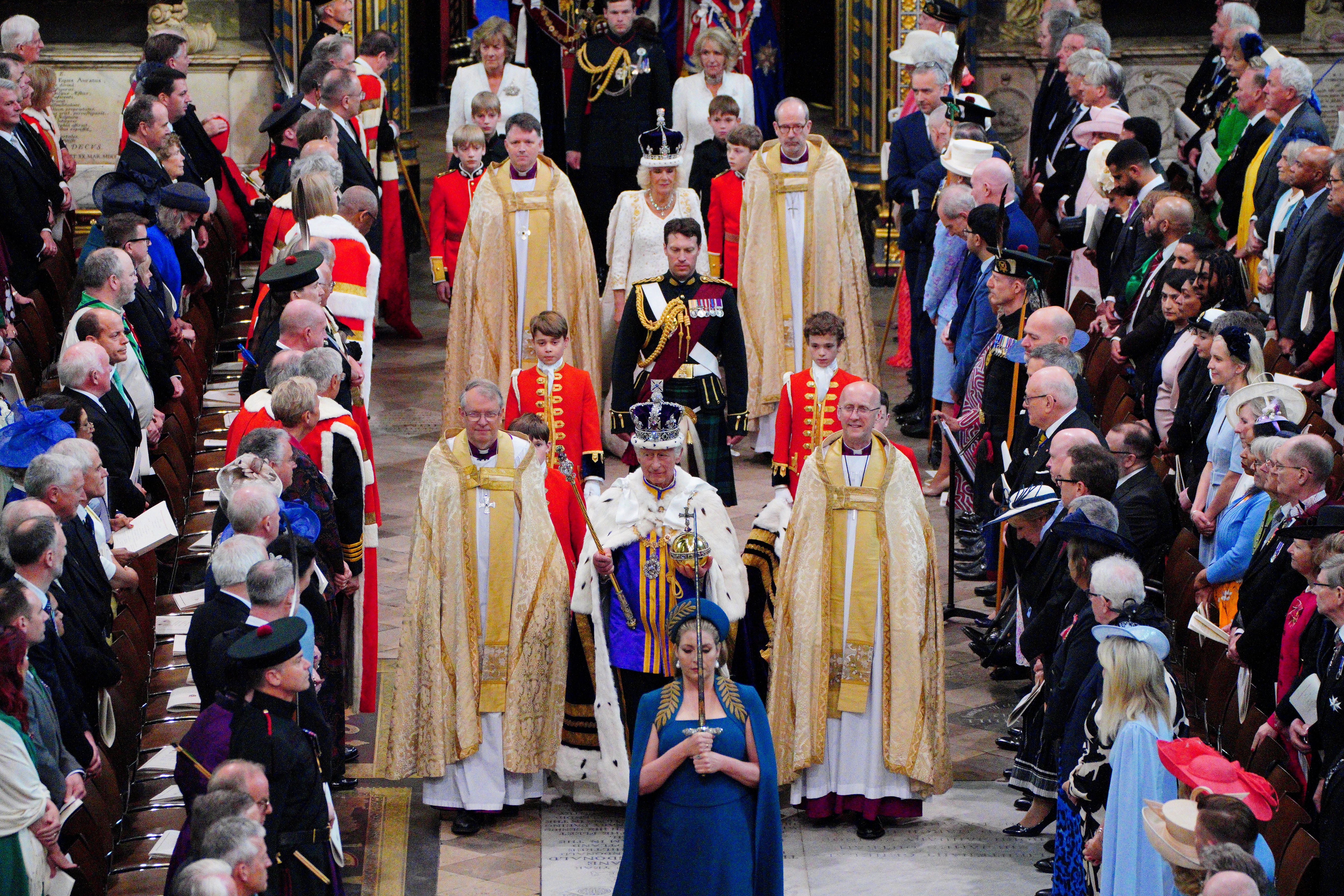 The King, wearing the Imperial State Crown, is followed by Queen Camilla as they leave Westminster Abbey (Ben Birchall/PA)