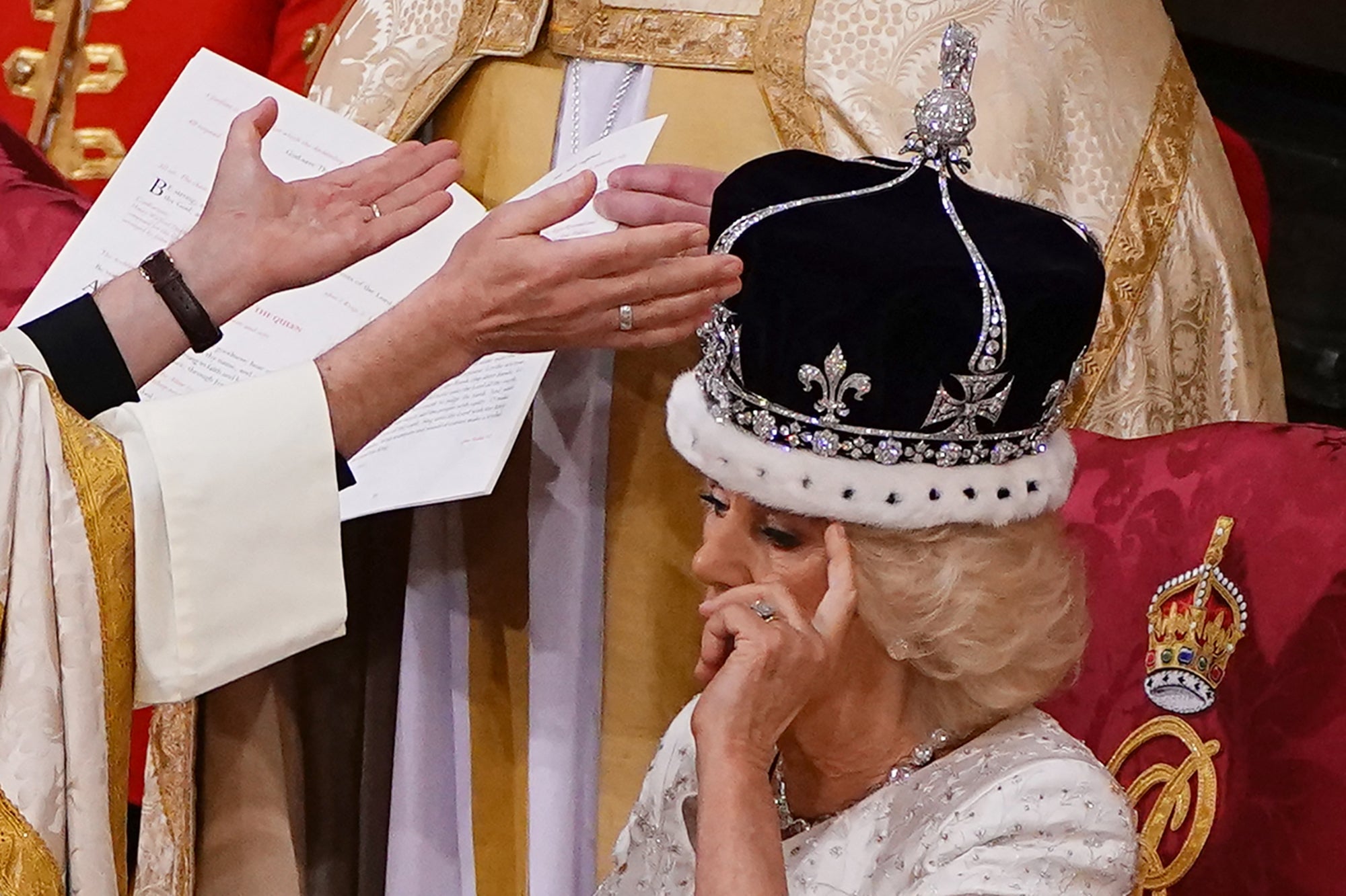 Camilla adjusts her hair as she is crowned Queen by the Archbishop of Canterbury