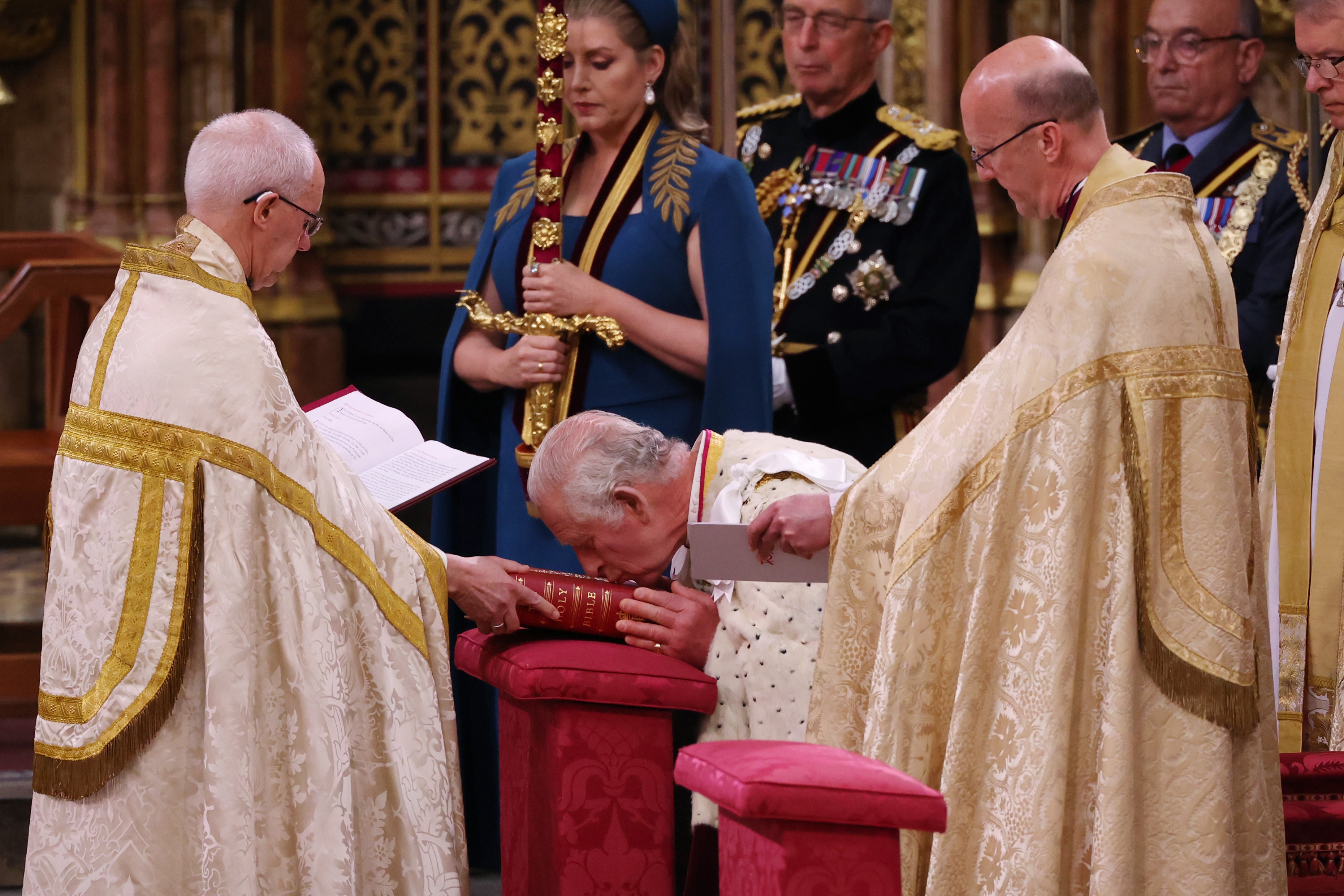 King Charles III kisses the bible