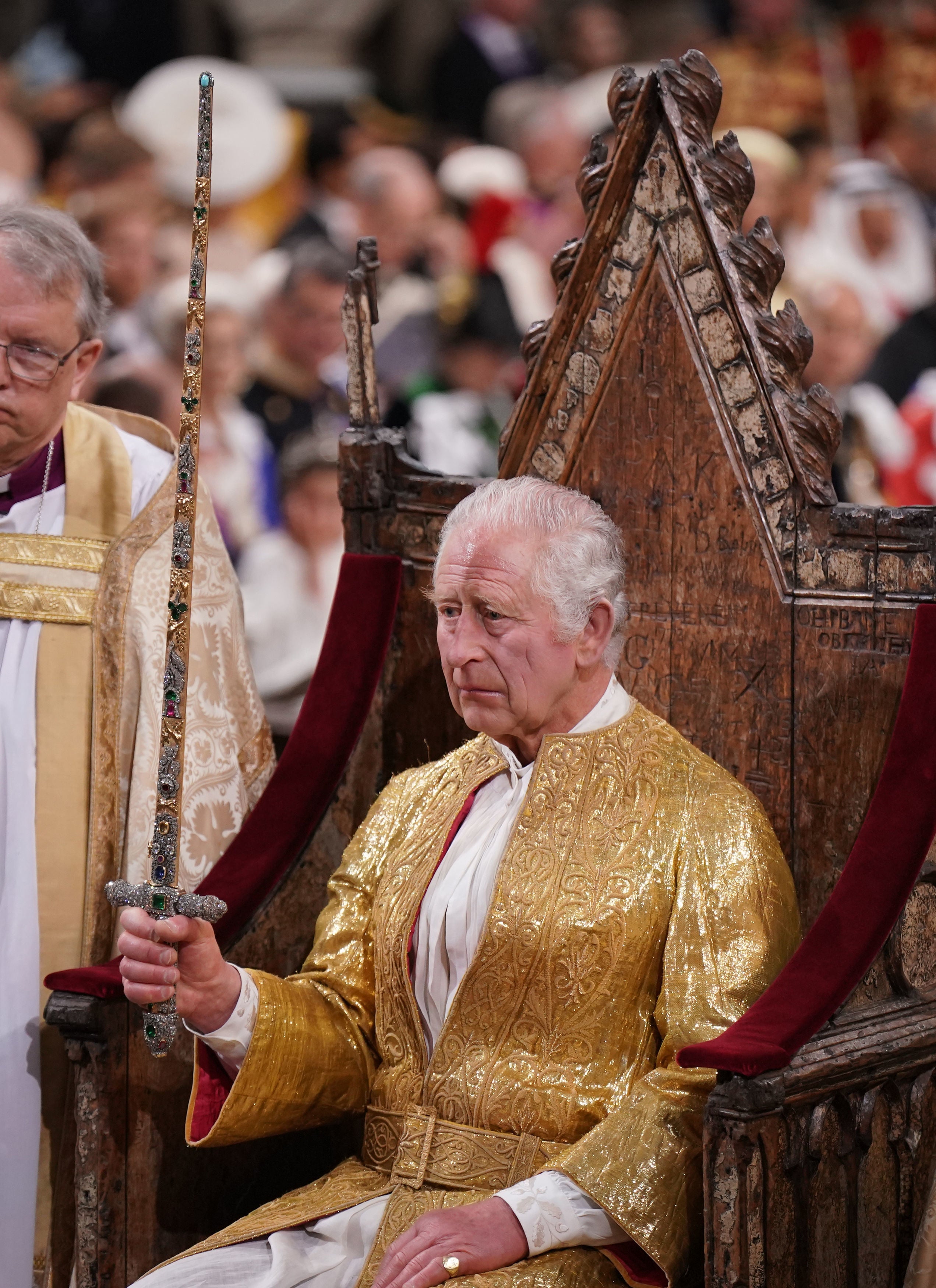 King Charles III holds a sword during the ceremony