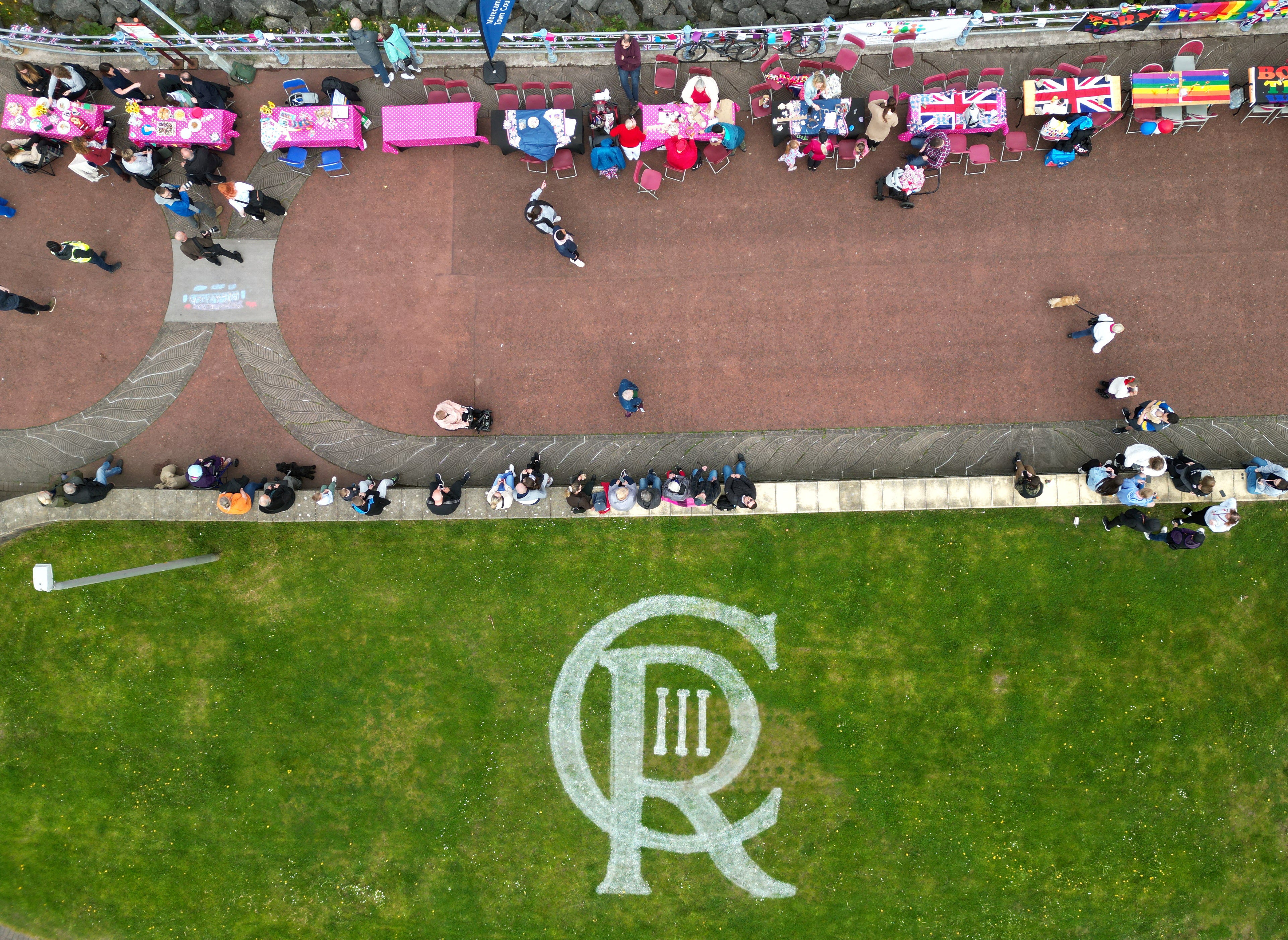 King Charles’s insignia painted on the grass along the seafront in Morecambe