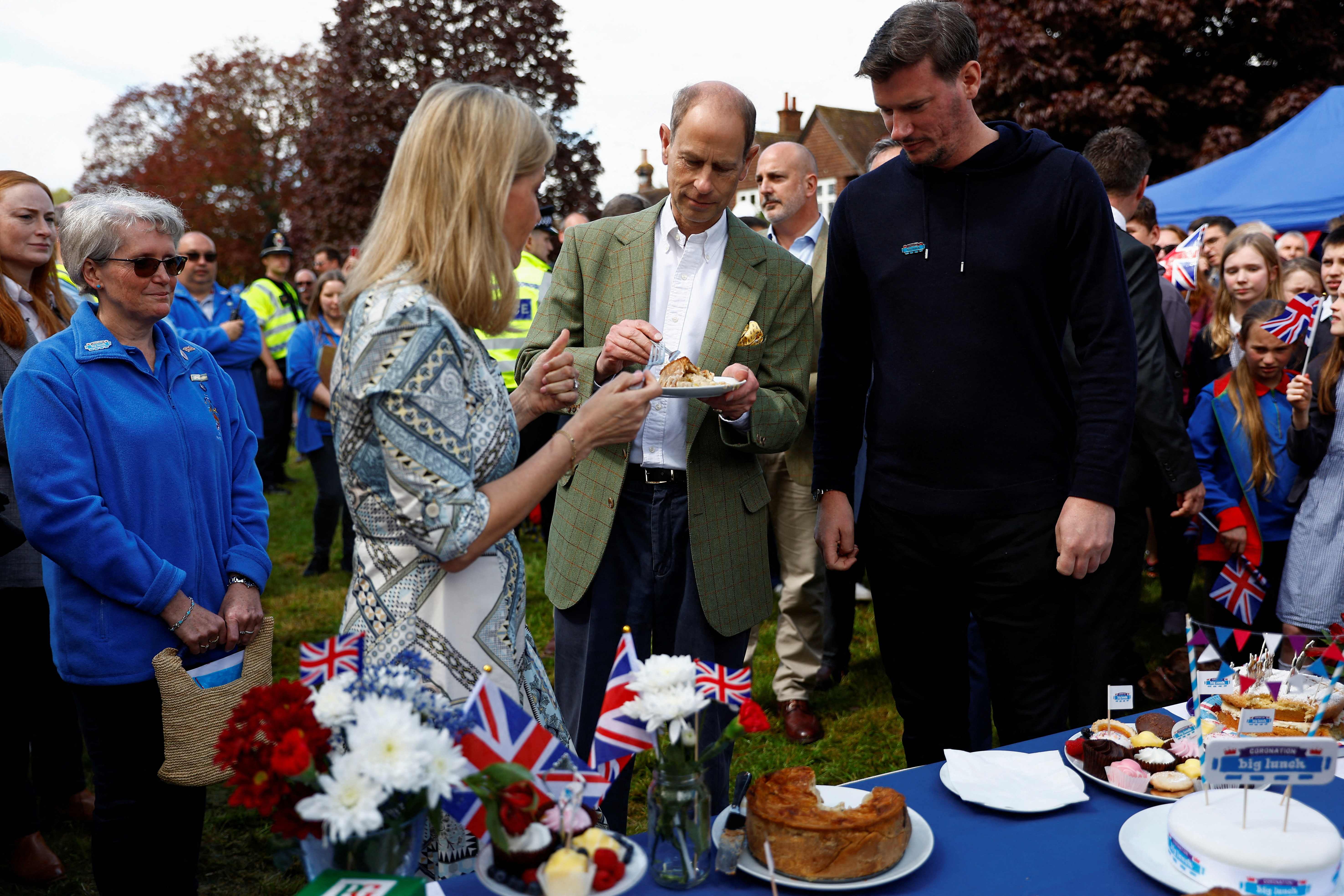 The Duke and Duchess of Edinburgh sample a coronation chicken pie at a Big Lunch with residents and representatives from the Royal British Legion, the Scouts and the Guides