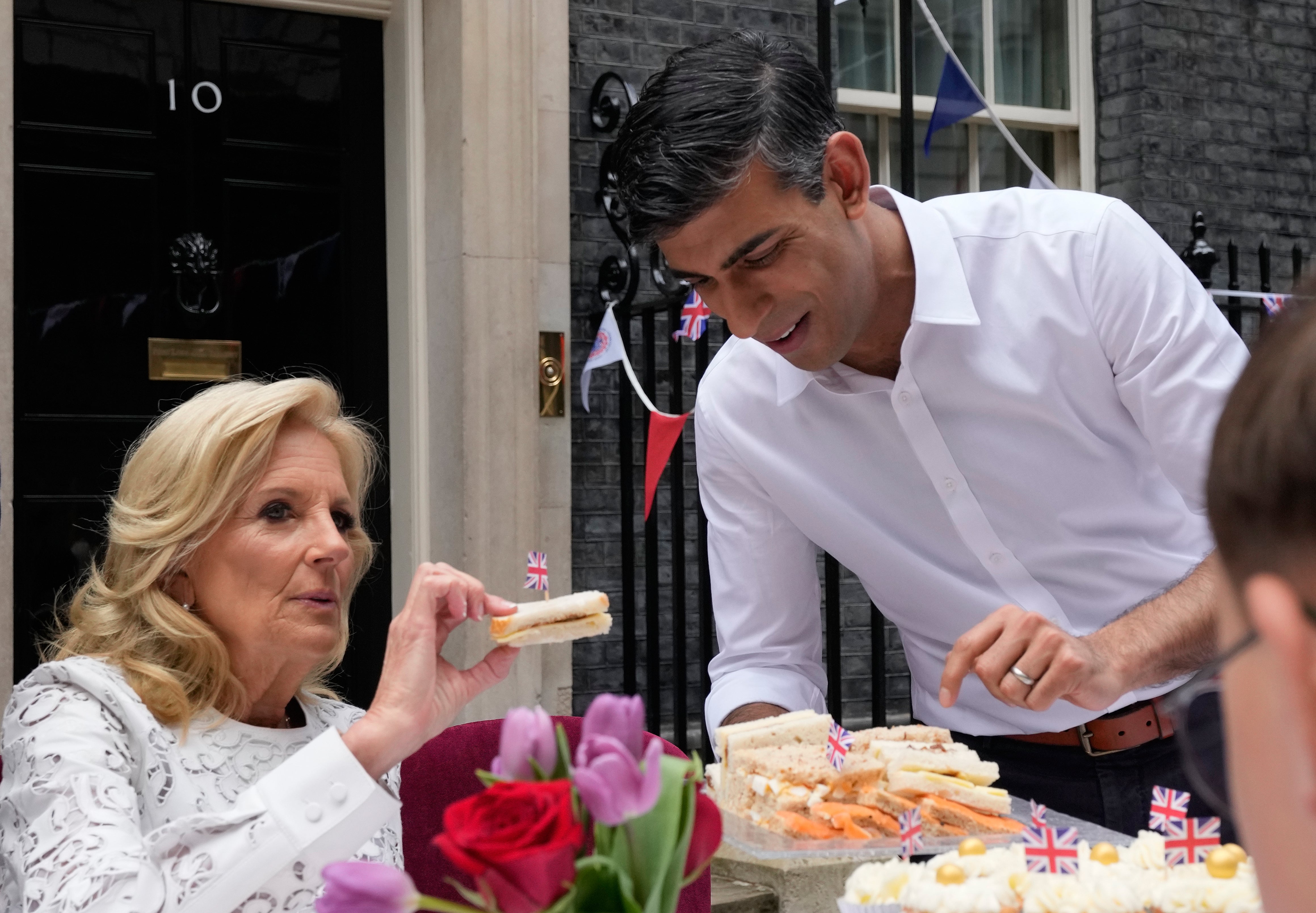 Rishi Sunak holds plate of sandwiches as Jill Biden takes one