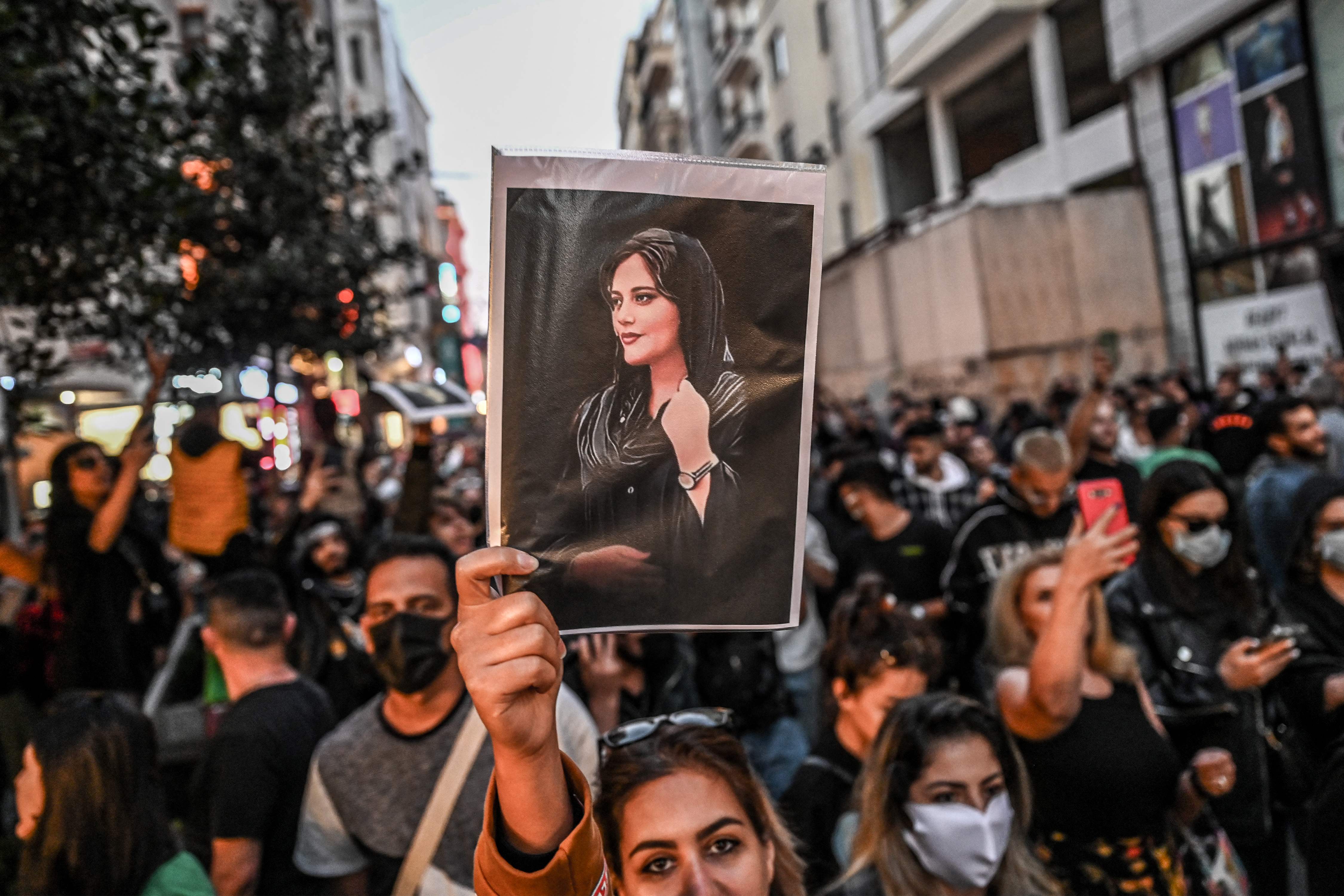 A protester holds a portrait of Mahsa Amini during a demonstration in support of Amini, a young Iranian woman who died after being arrested in Tehran by the Islamic Republic's morality police