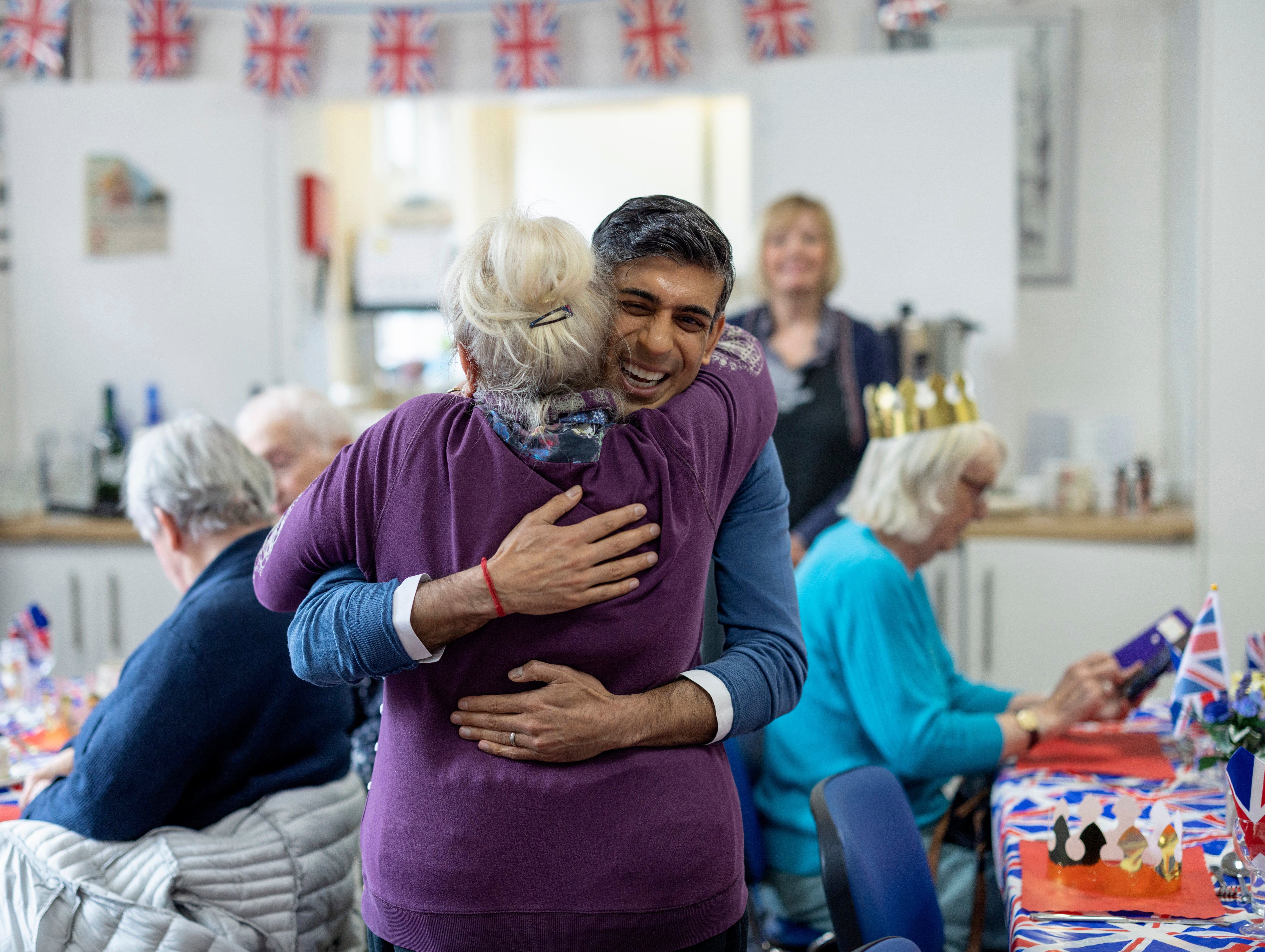 Rishi Sunak hugs a lunch club member at Mill End Community Centre in Rickmansworth, Herts on Monday