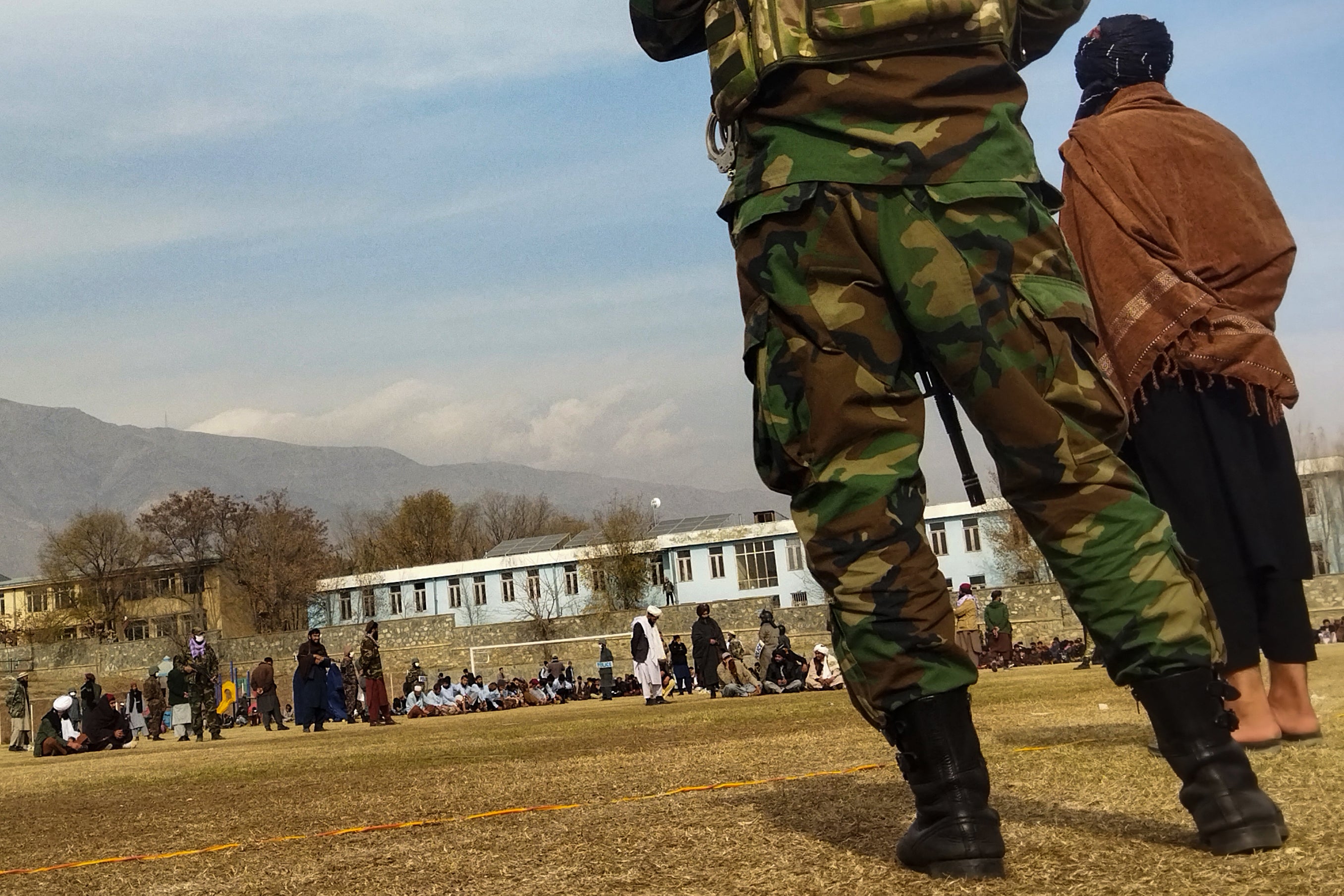 Taliban security personnel keep watch ahead of the court flogging of women and men at a football stadium in Charikar city of Parwan province in December 2022