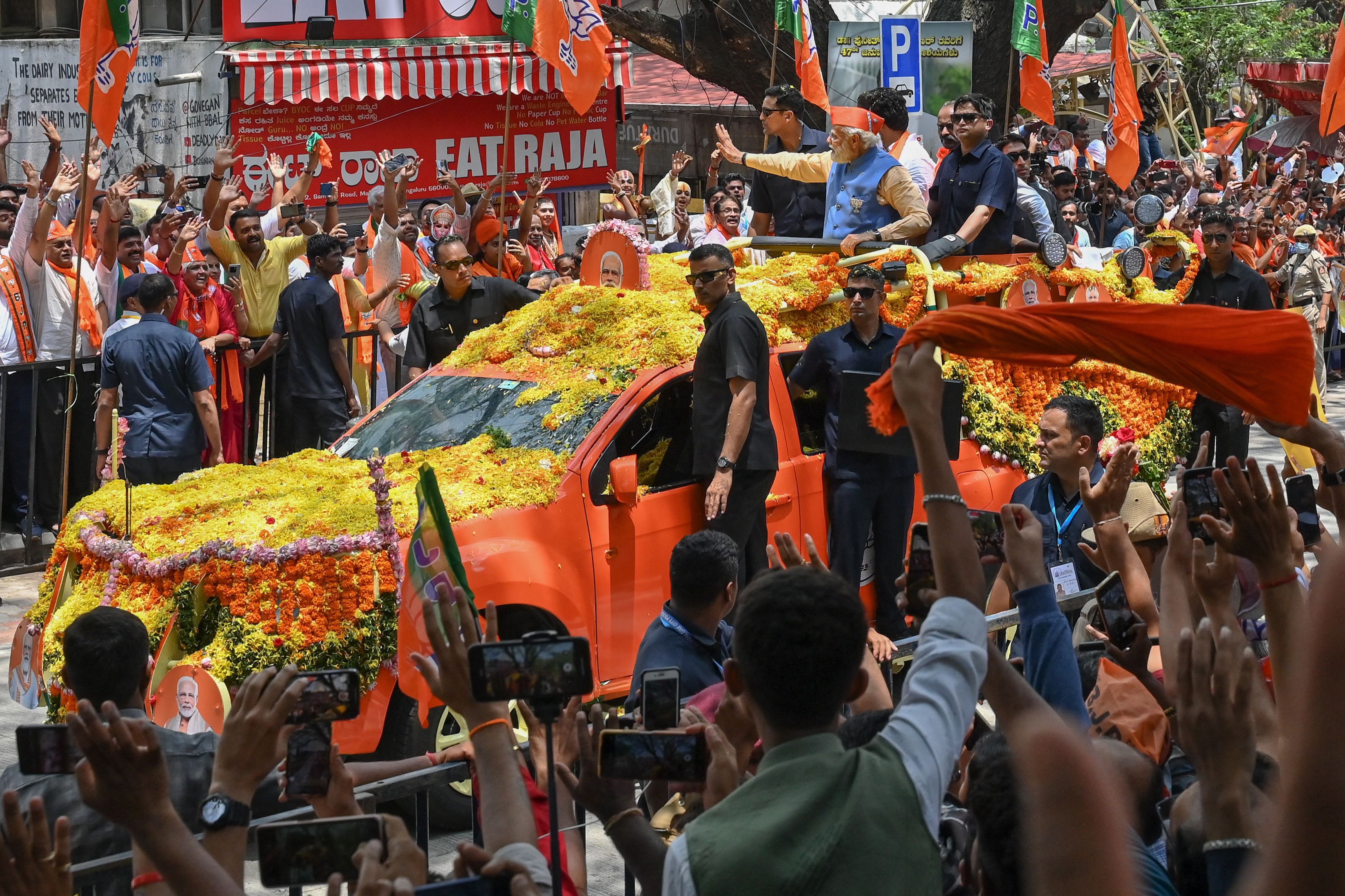 Indian prime minister Narendra Modi waves to supporters from atop a vehicle during a road rally held by the Bharatiya Janata Party (BJP) in Bengaluru ahead of the Karnataka assembly election