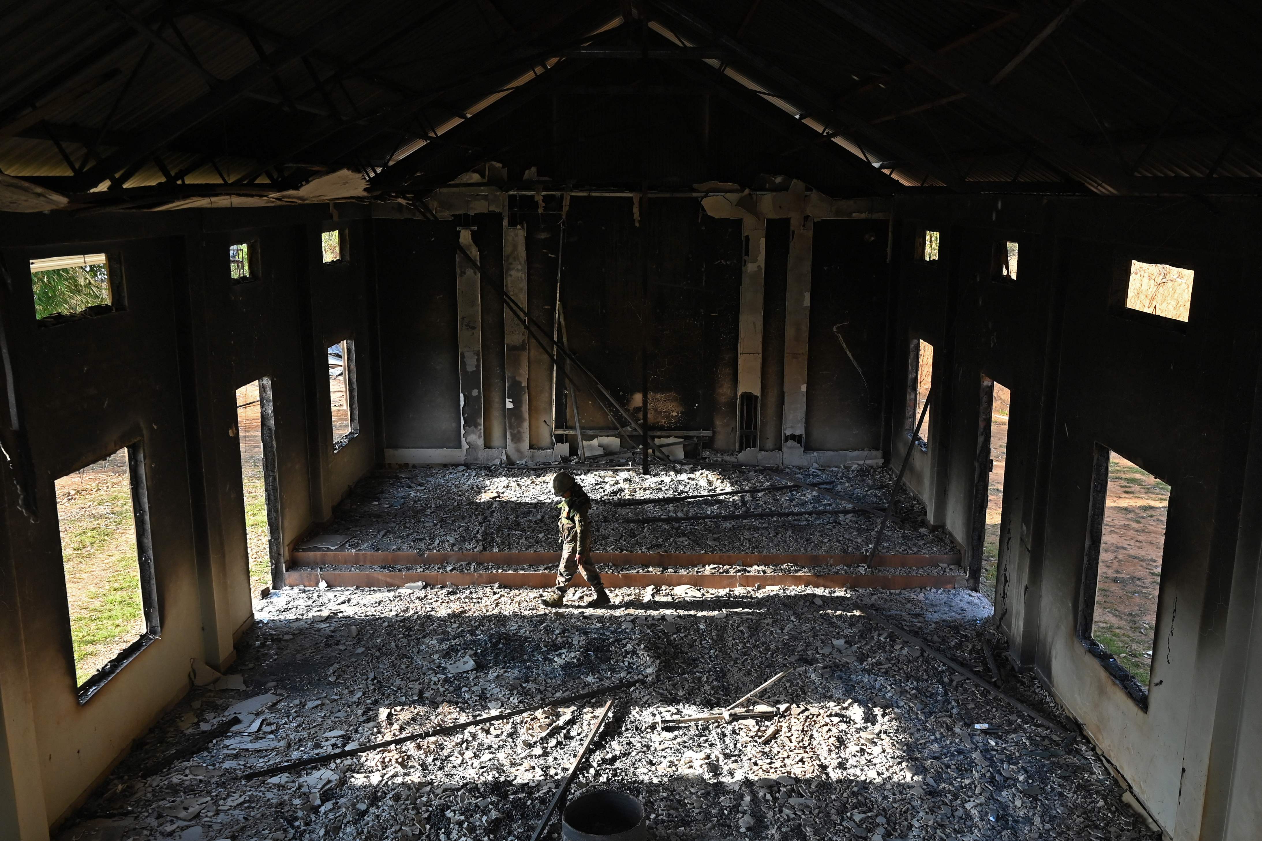 An Indian army soldier inspects the debris of a ransacked church that was set on fire by a mob in the ethnic violence hit area of Heiroklian village on 8 May