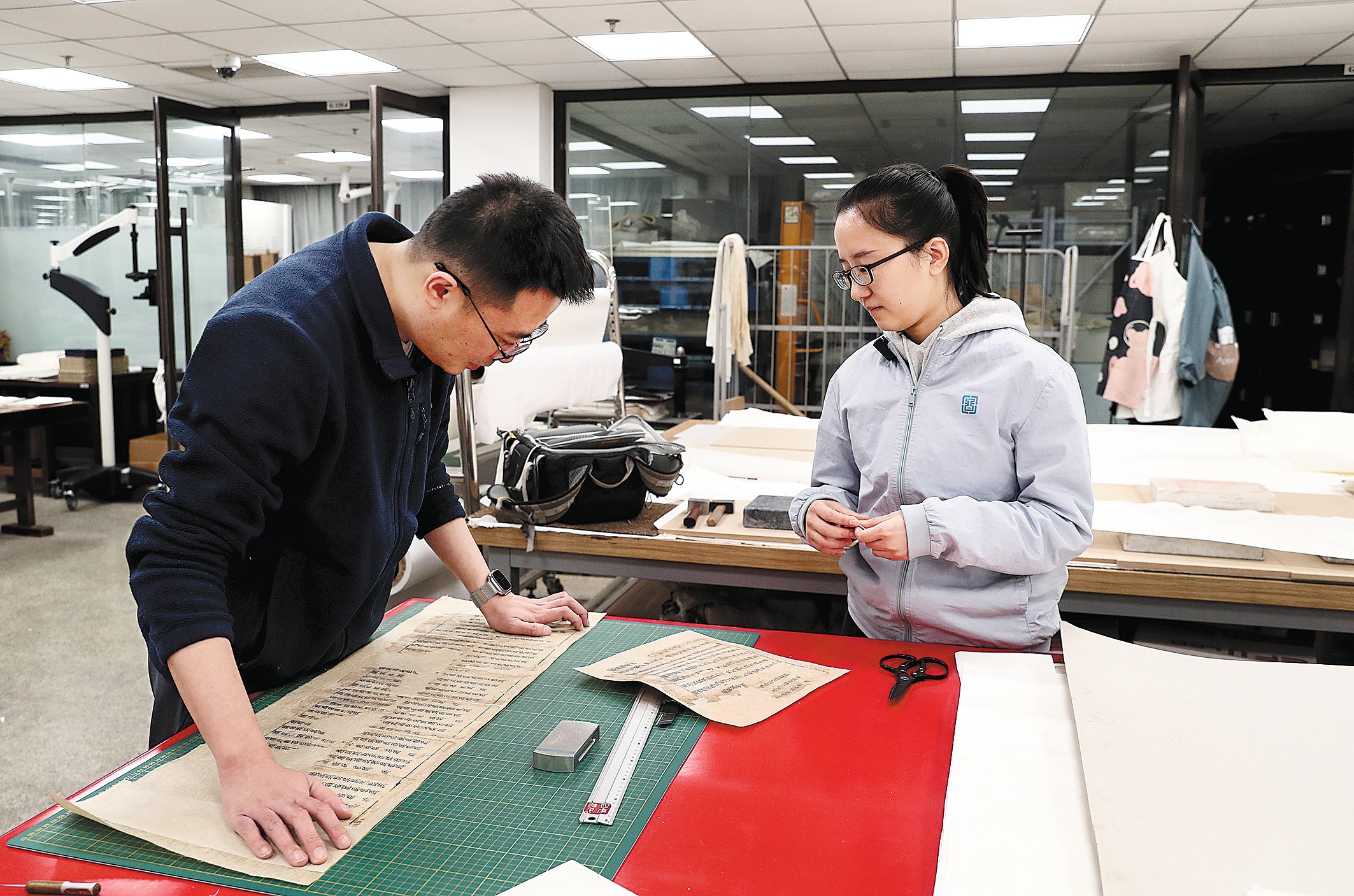 Song discusses ancient book repair methods with her colleague