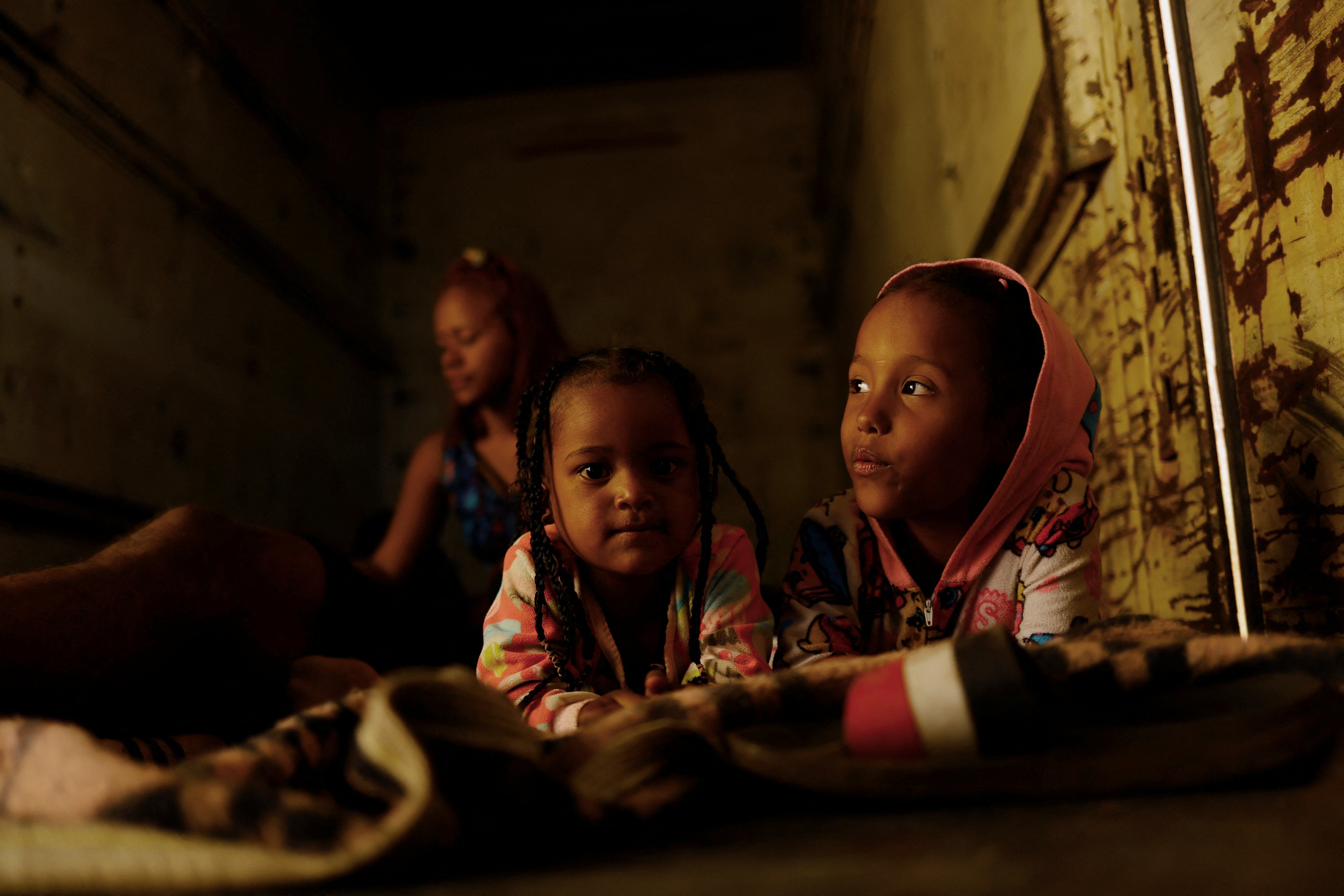 Seven-year-old Cathaleya, on the right, rests with another migrant girl inside a train carriage as she travels with her family