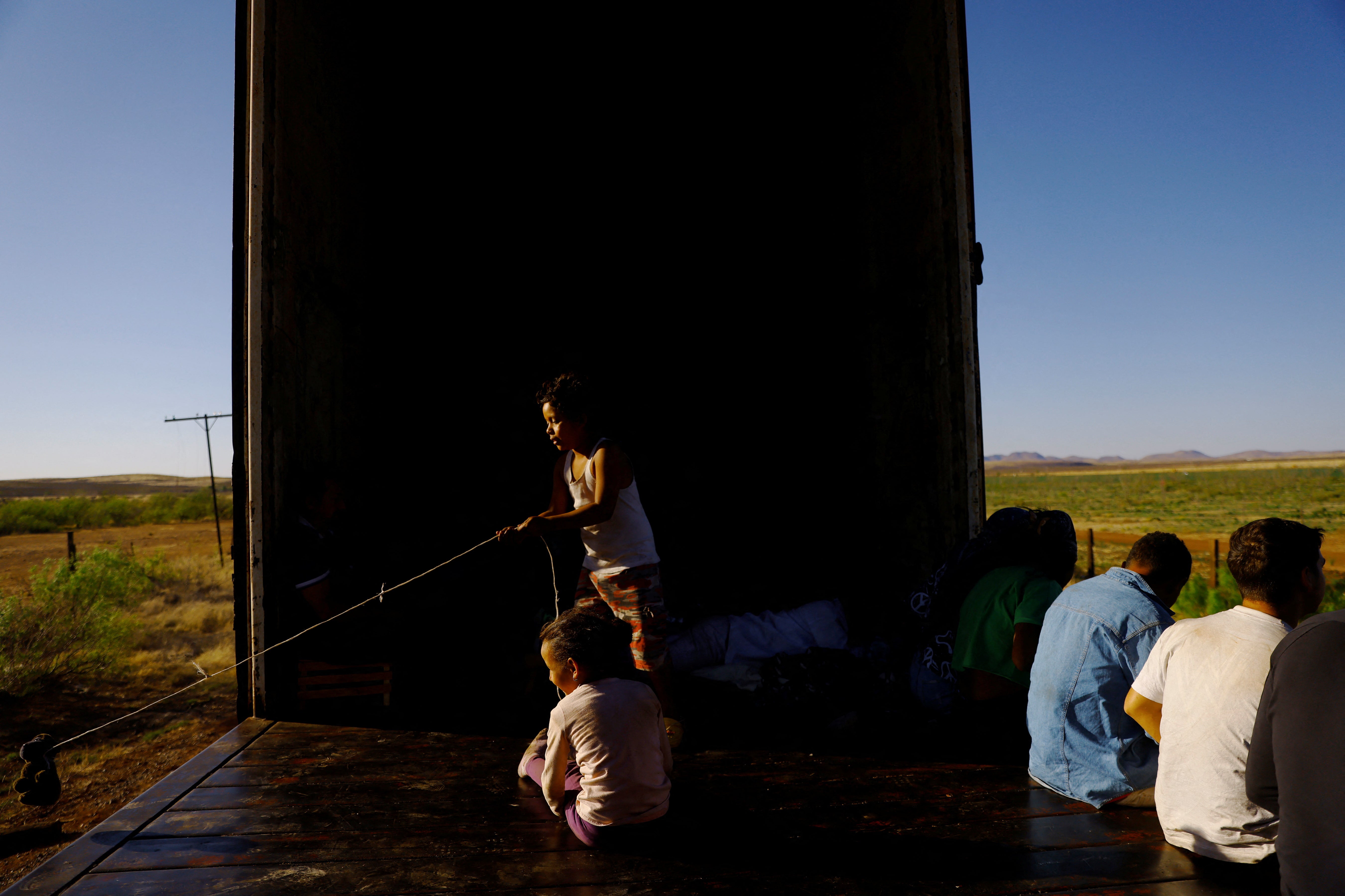 Victoria and Alan, migrant children traveling with their family, play on a train