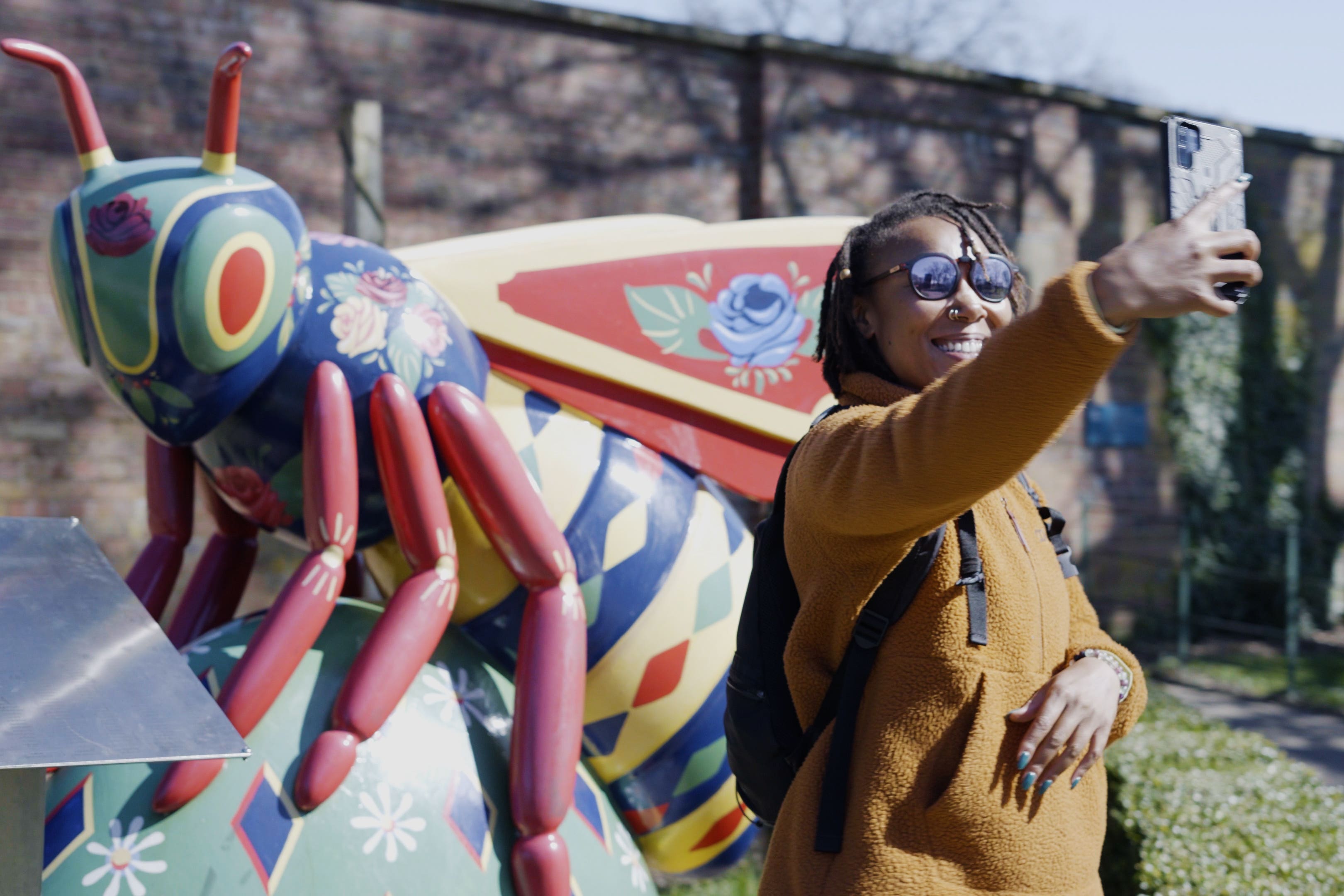 Rhiane Fatinikun, founder of Black Girls Hike, takes photos of Heaton Park in Manchester as part of Historic England’s Missing Pieces Project (Historic England/PA)