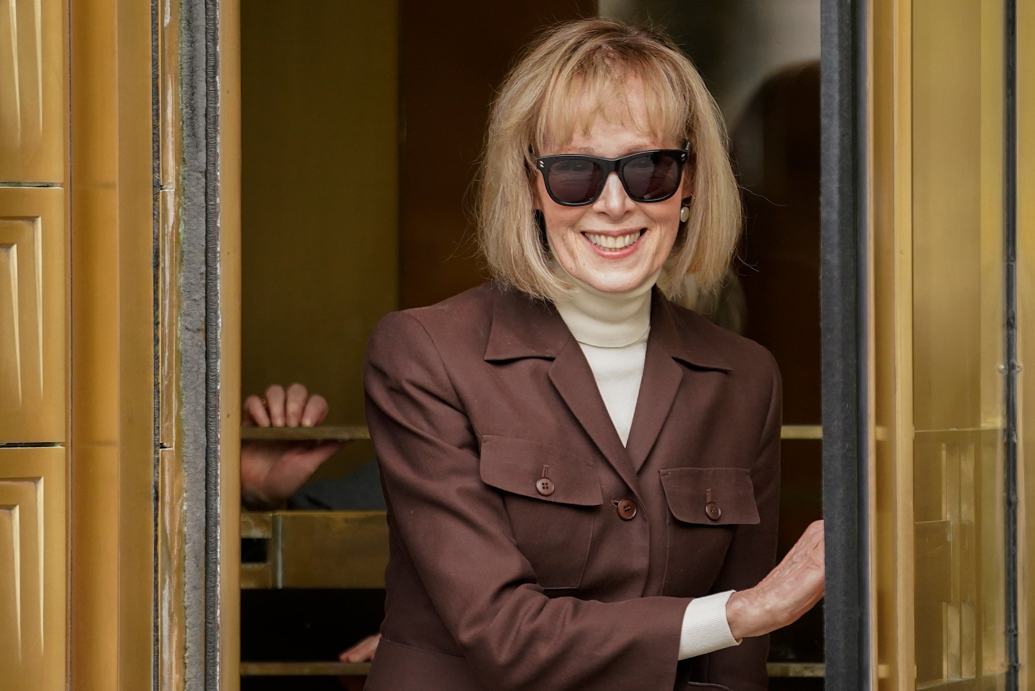 E Jean Carroll, center, walks out of Manhattan federal court, Tuesday, May 9, 2023, in New York