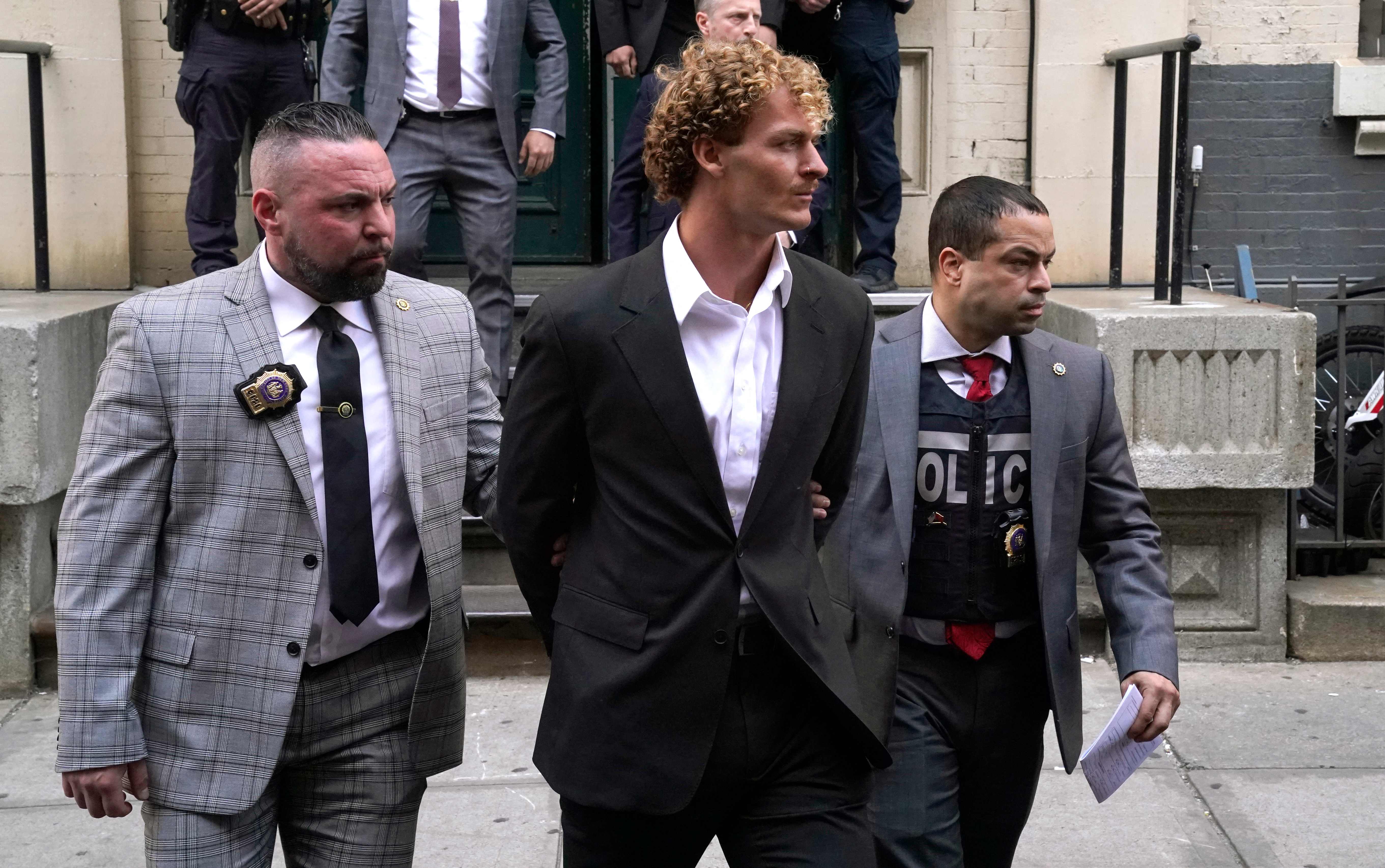 US Marine veteran Daniel Penny (center) is walked out of the New York Police Department 5th Precinct in Lower Manhattan, May 12, 2023