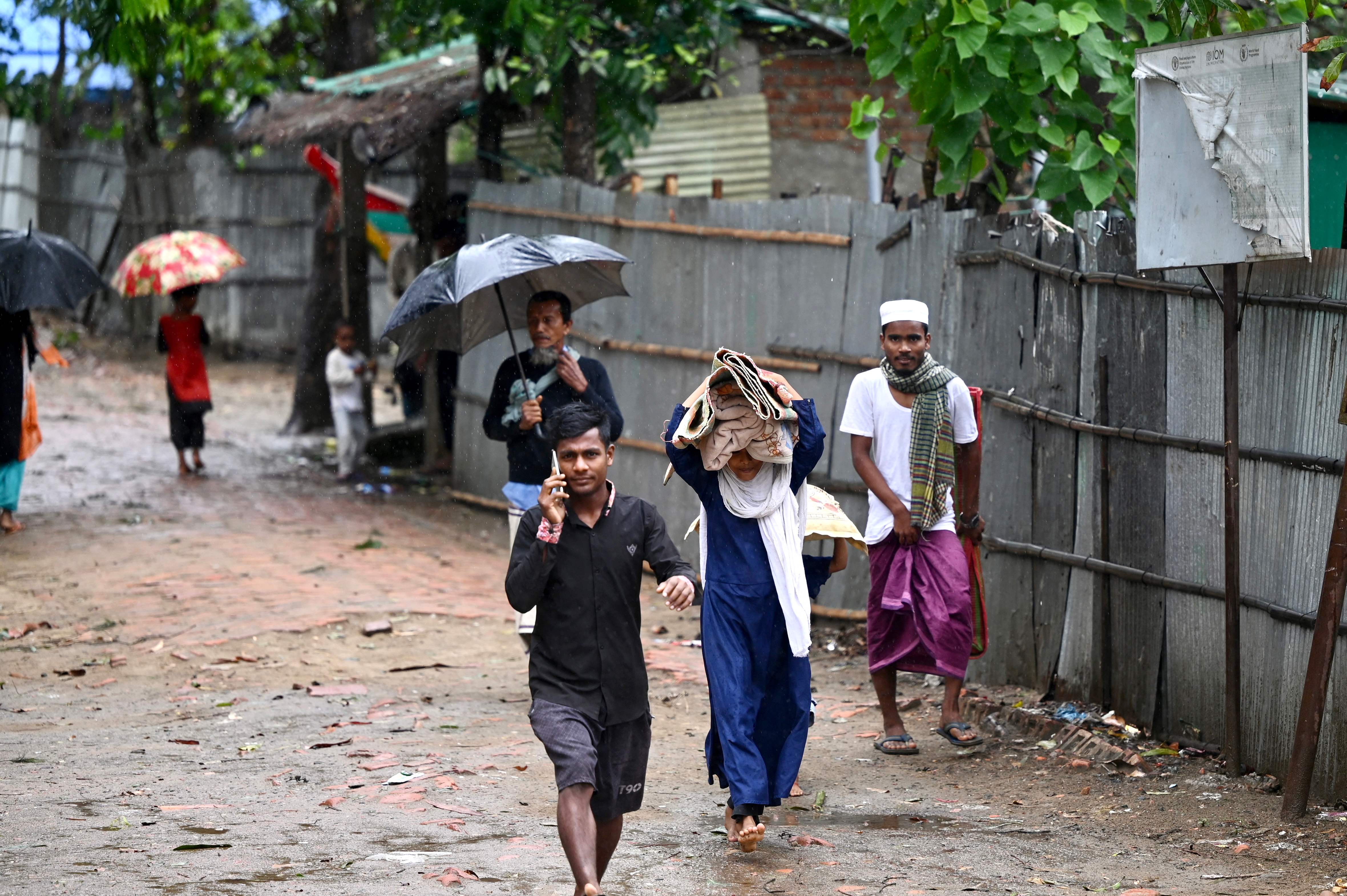 People carry their belongings to a shelter in Shahpori island on the outskirts of Teknaf