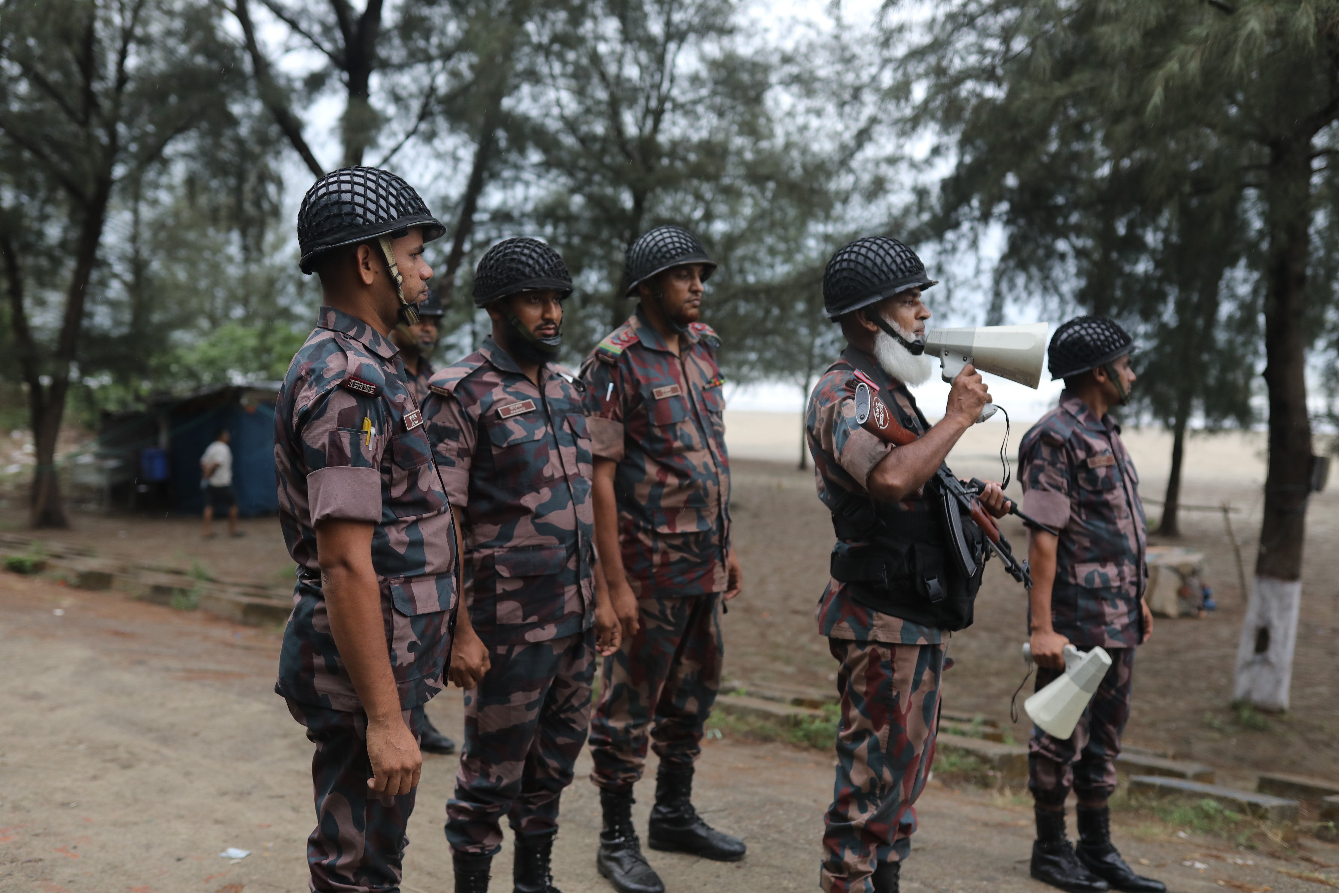 Bangladeshi Border Guards warn people to leave their homes and take shelter at cyclone shelter