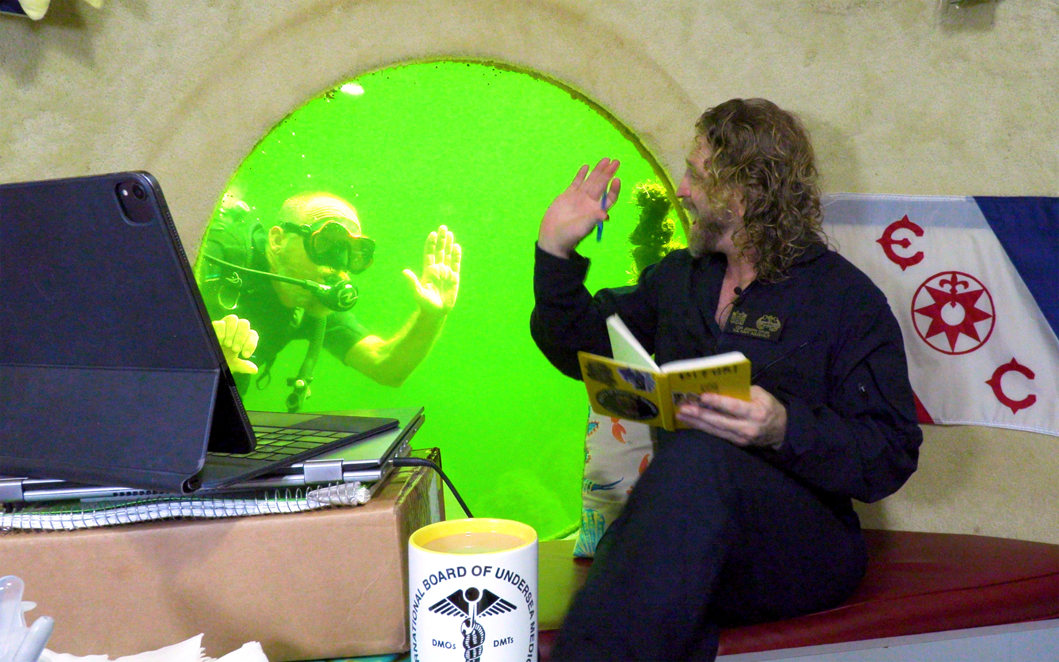 Dr Joseph Dituri waves to a visitor to his underwater habitat in Florida