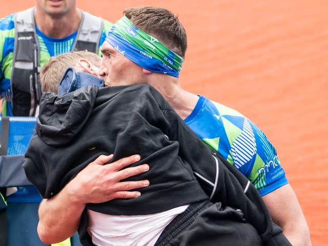 <p>Kevin Sinfield carries Rob Burrow across the finish line of the Leeds Marathon </p>
