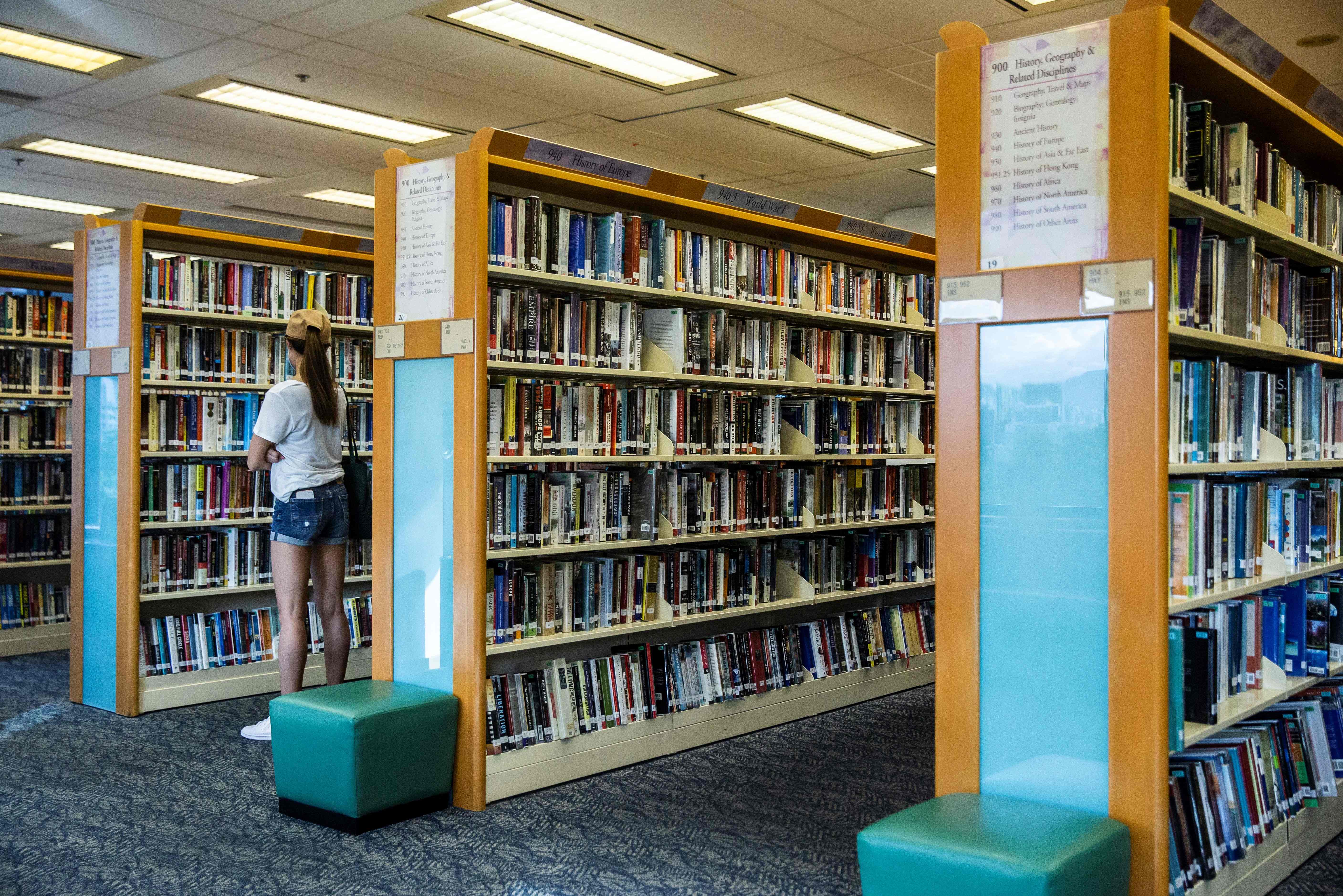 File: A woman looks at books in a public library in Hong Kong