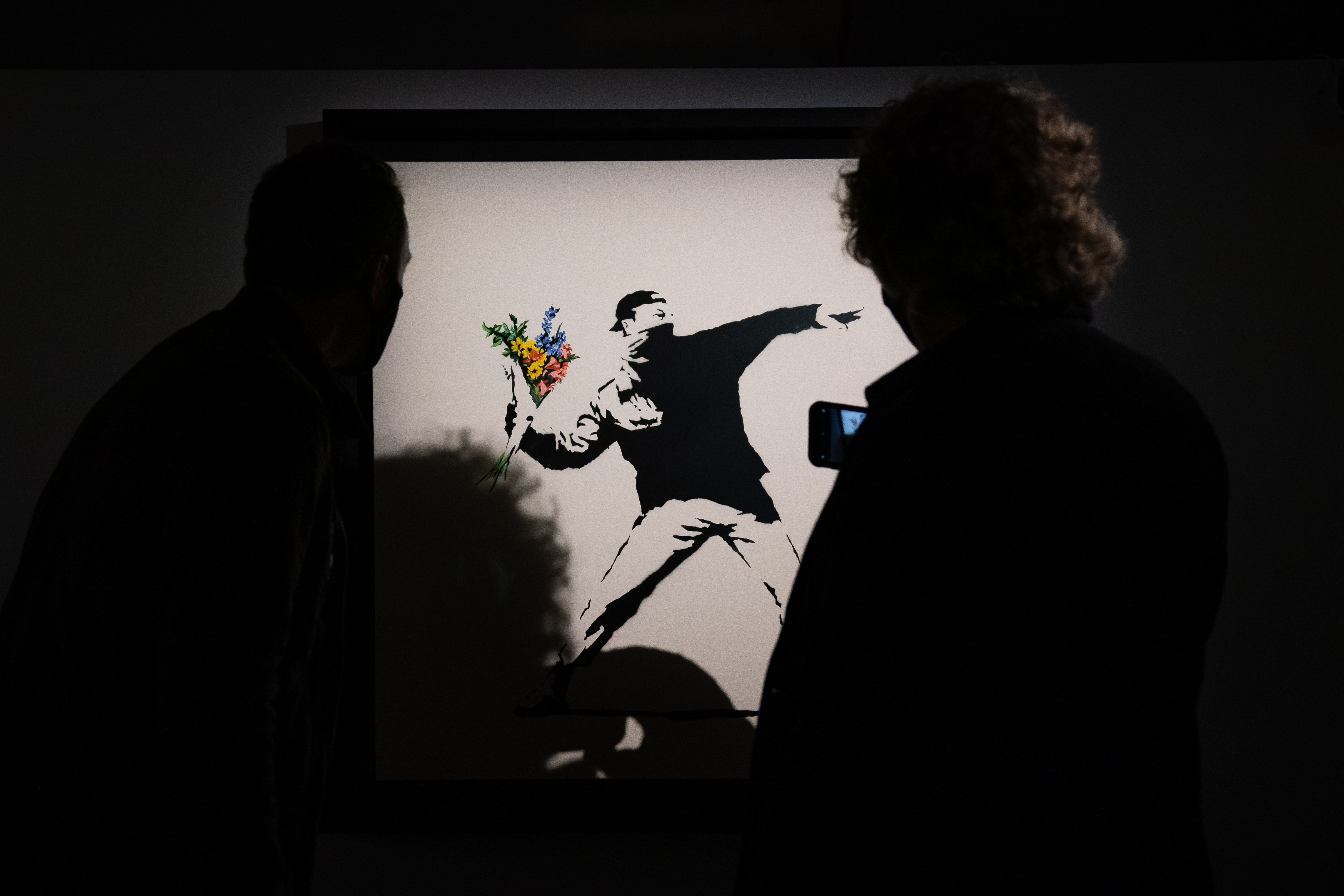 People observe a Banksy artwork (Aaron Chown/PA)