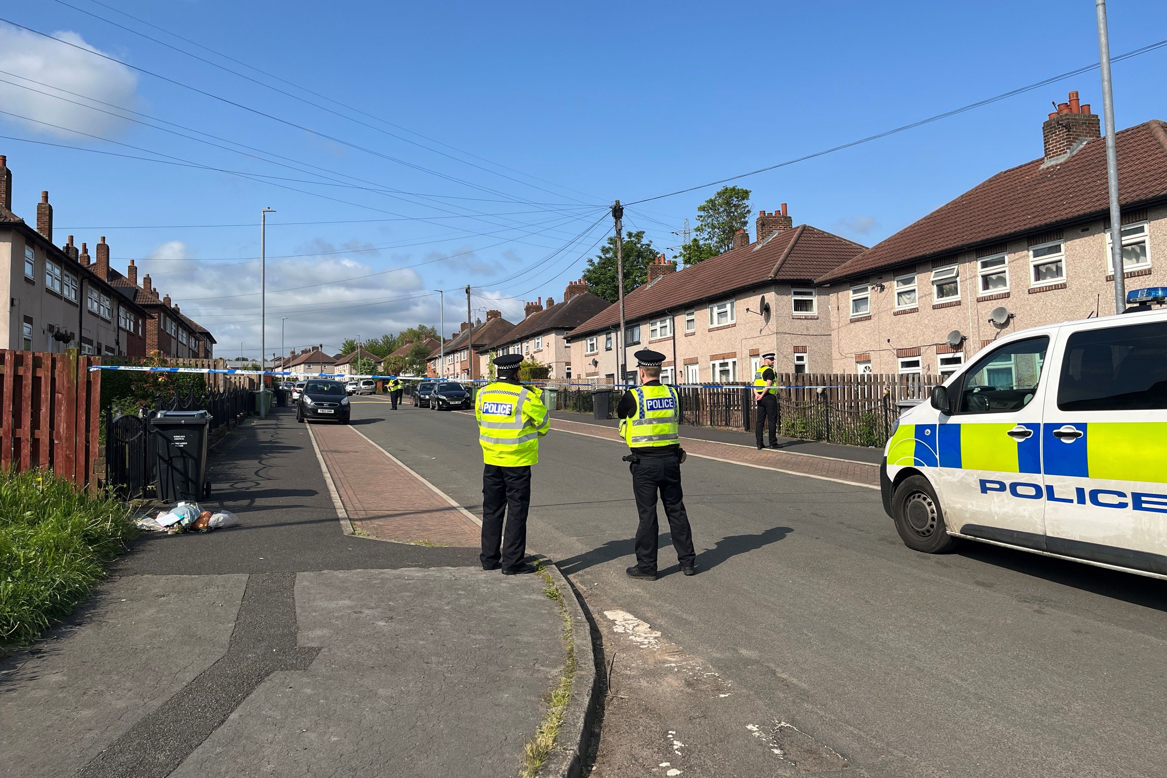 Police officers stand by a cordon on Harpe Inge, Huddersfield