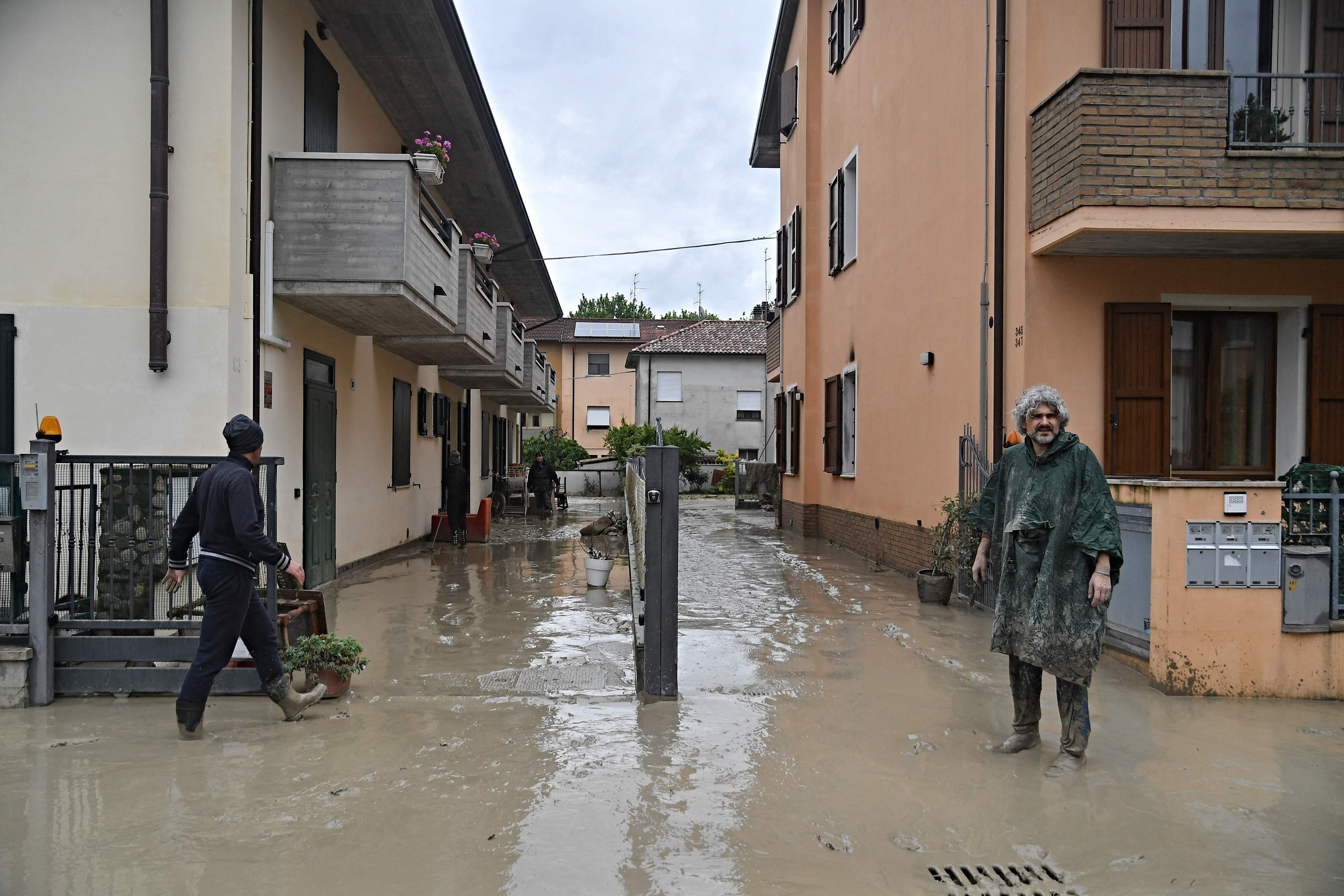 Pedestrians walk in a flooded street of the San Rocco district