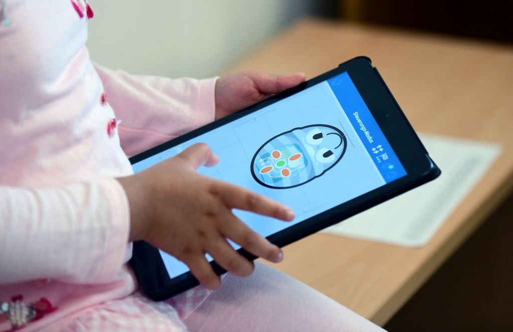 A pupil works with an iPad during a summer project at the primary school ‘Sonnenschule’ in Beckum, western Germany, on 6 July, 2021