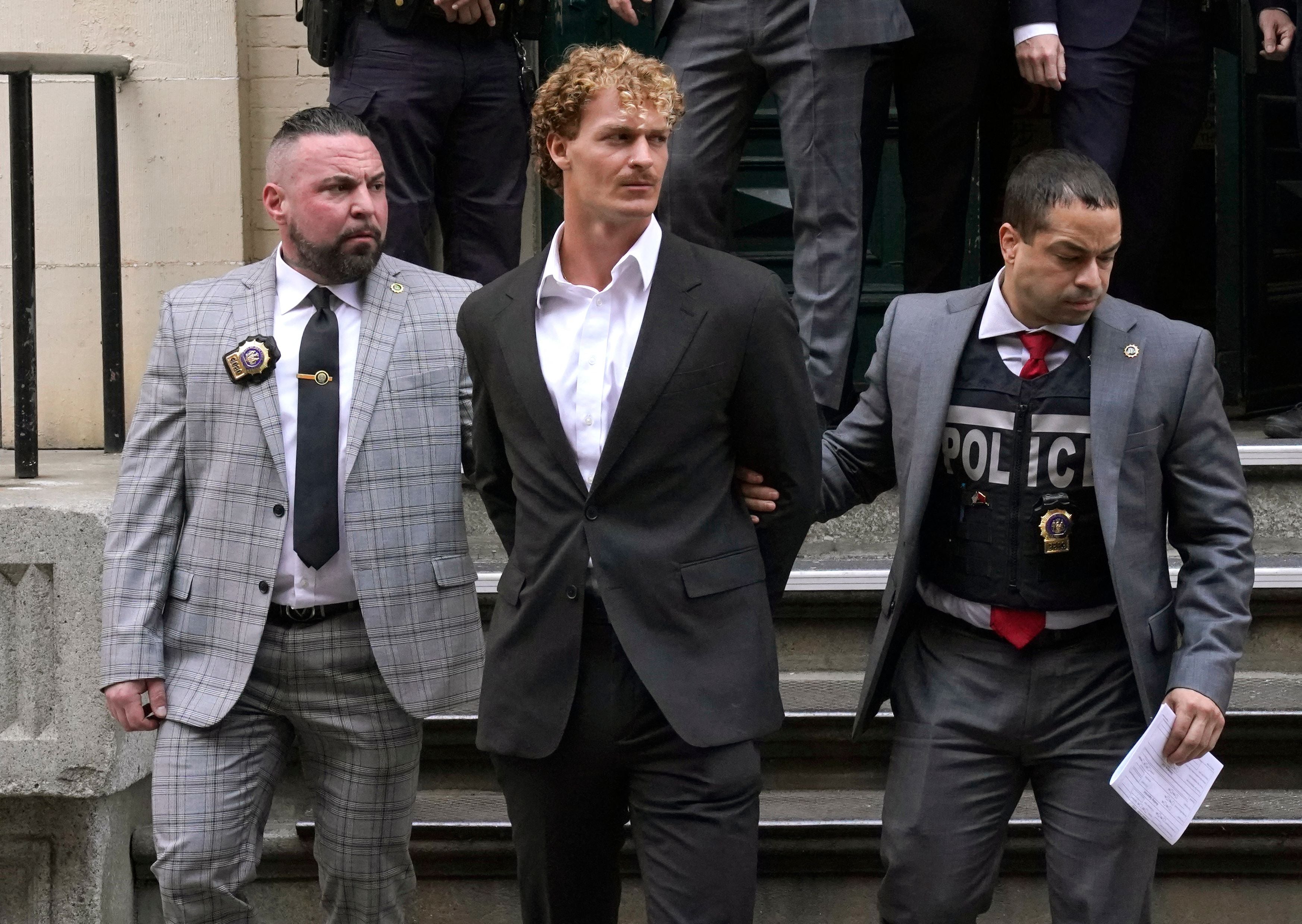 US Marine veteran Daniel Penny (C) is walked out of the New York Police Department 5th Precinct in Lower Manhattan, May 12, 2023 on his way to a arraignment after he surrendered to authorities after being charged with 2nd Degree Manslaughter in the chokehold death of Jordan Neely.