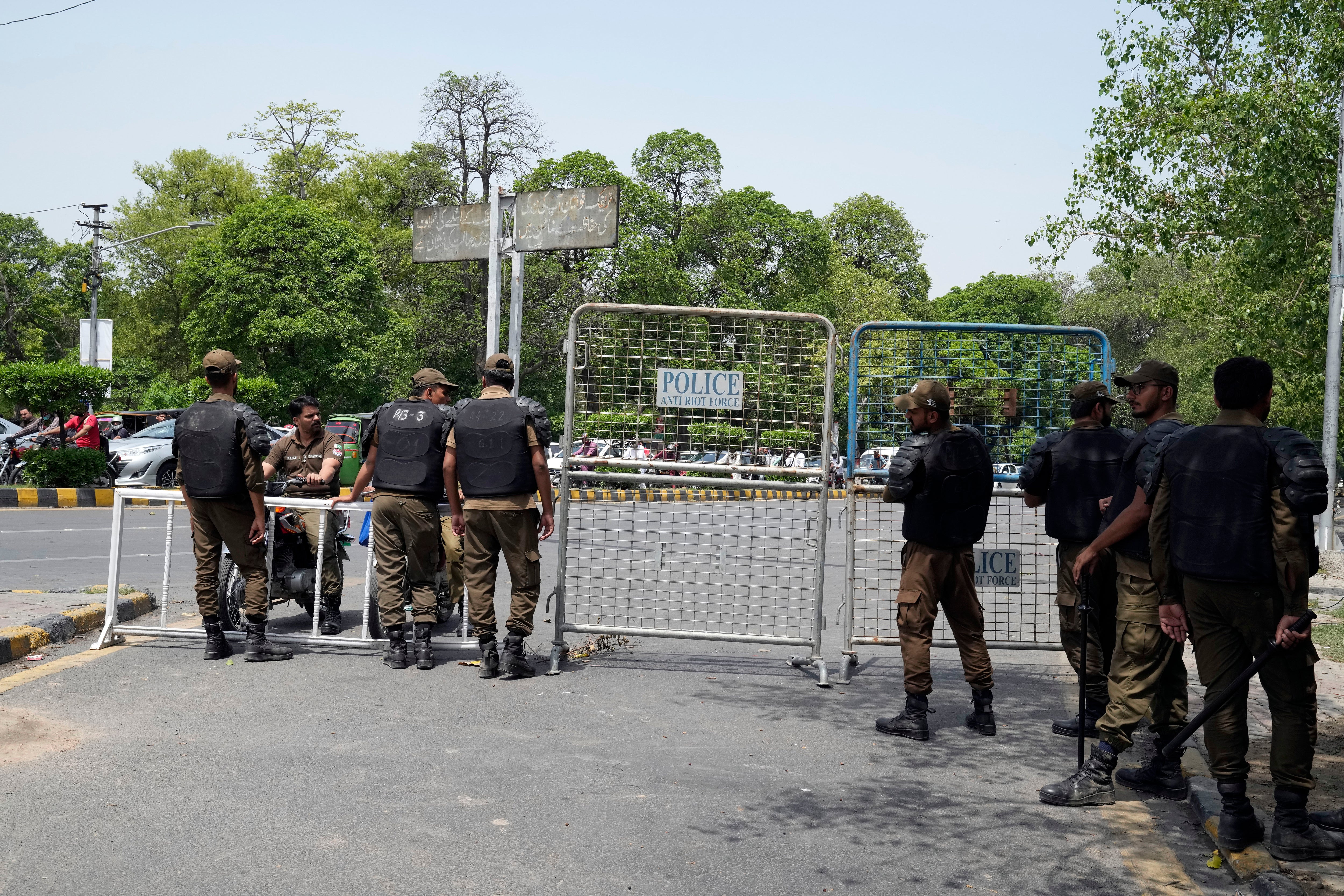 Pakistani security officials close a road outside the former Prime Minister Imran Khan's residence in Lahore on 18 May