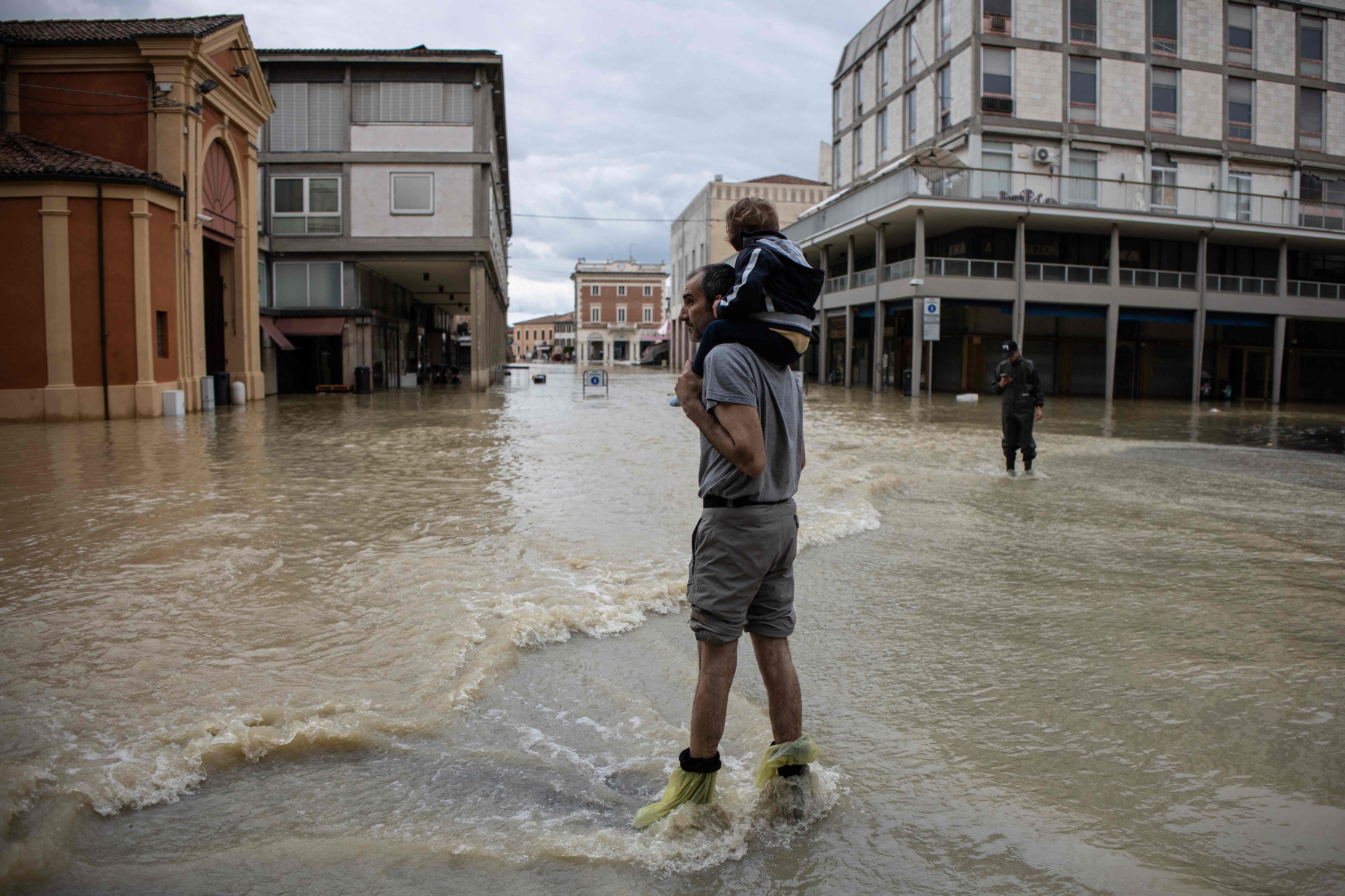 A resident carries a child in Lugo