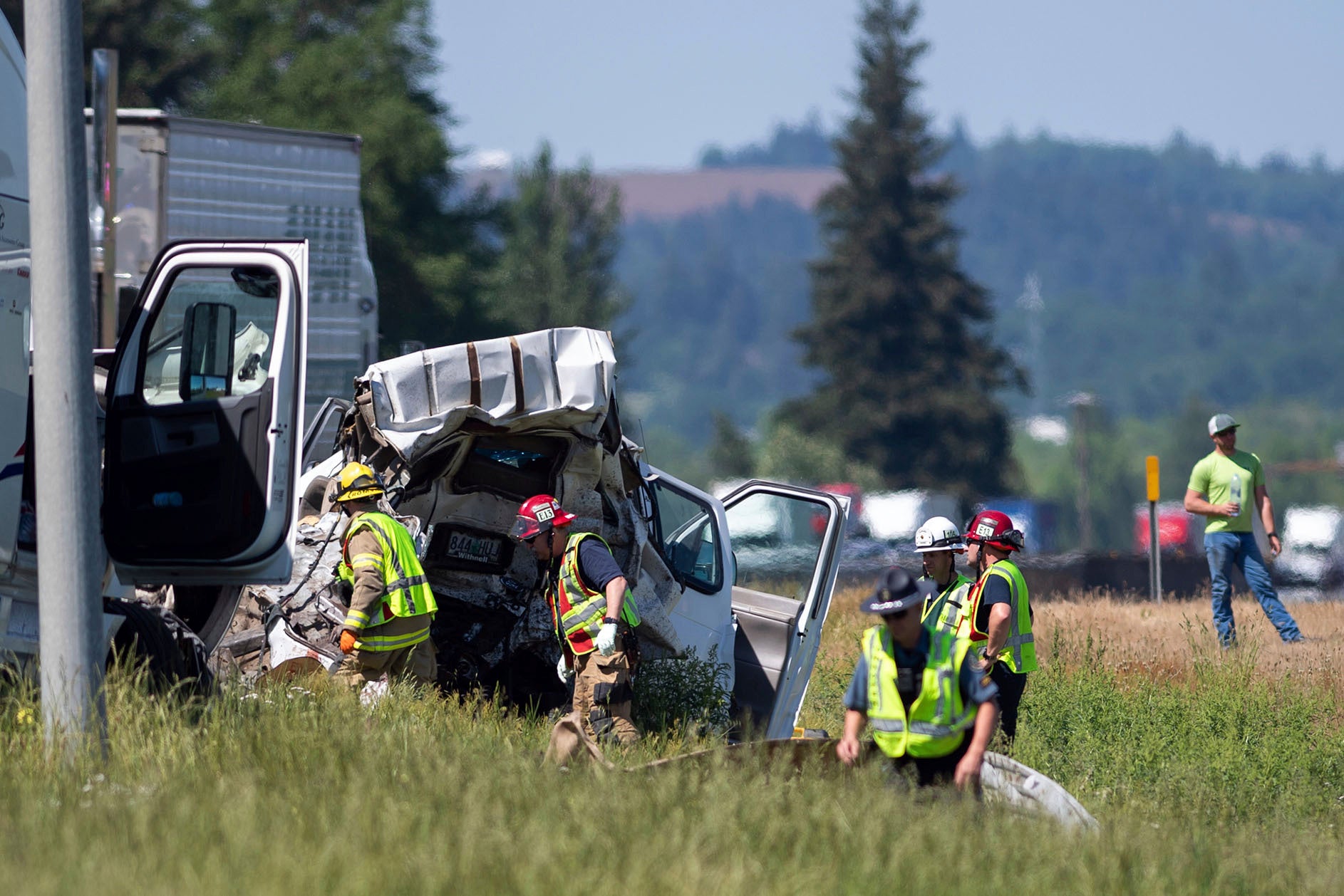 Oregon State Police troopers and firefighters work near the site of a wrecked tractor-trailer Thursday, May 18, 2023, along Interstate 5 in Albany, Ore.