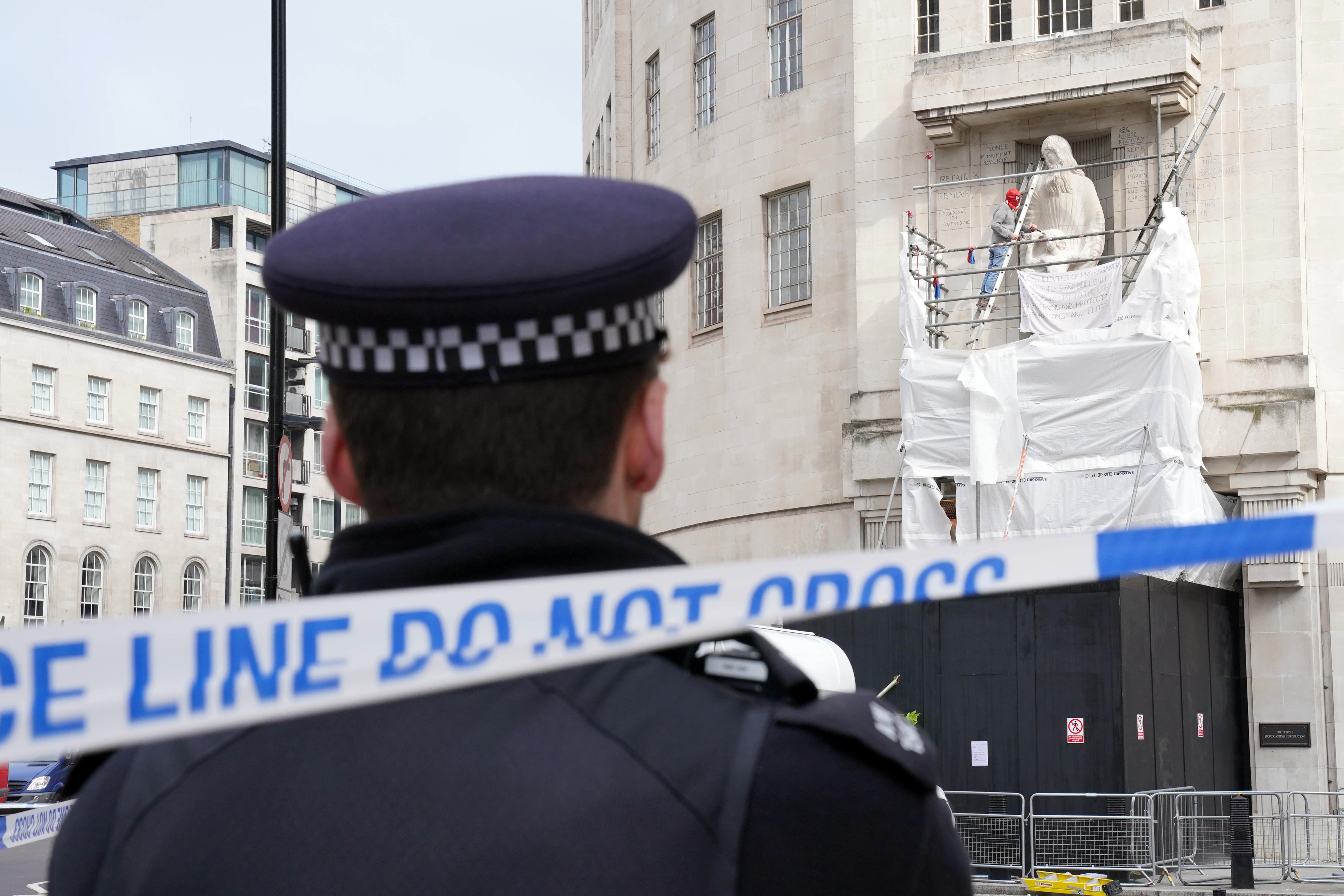 A man wearing a Spider-Man mask was seen on scaffolding surrounding sculpture on Saturday