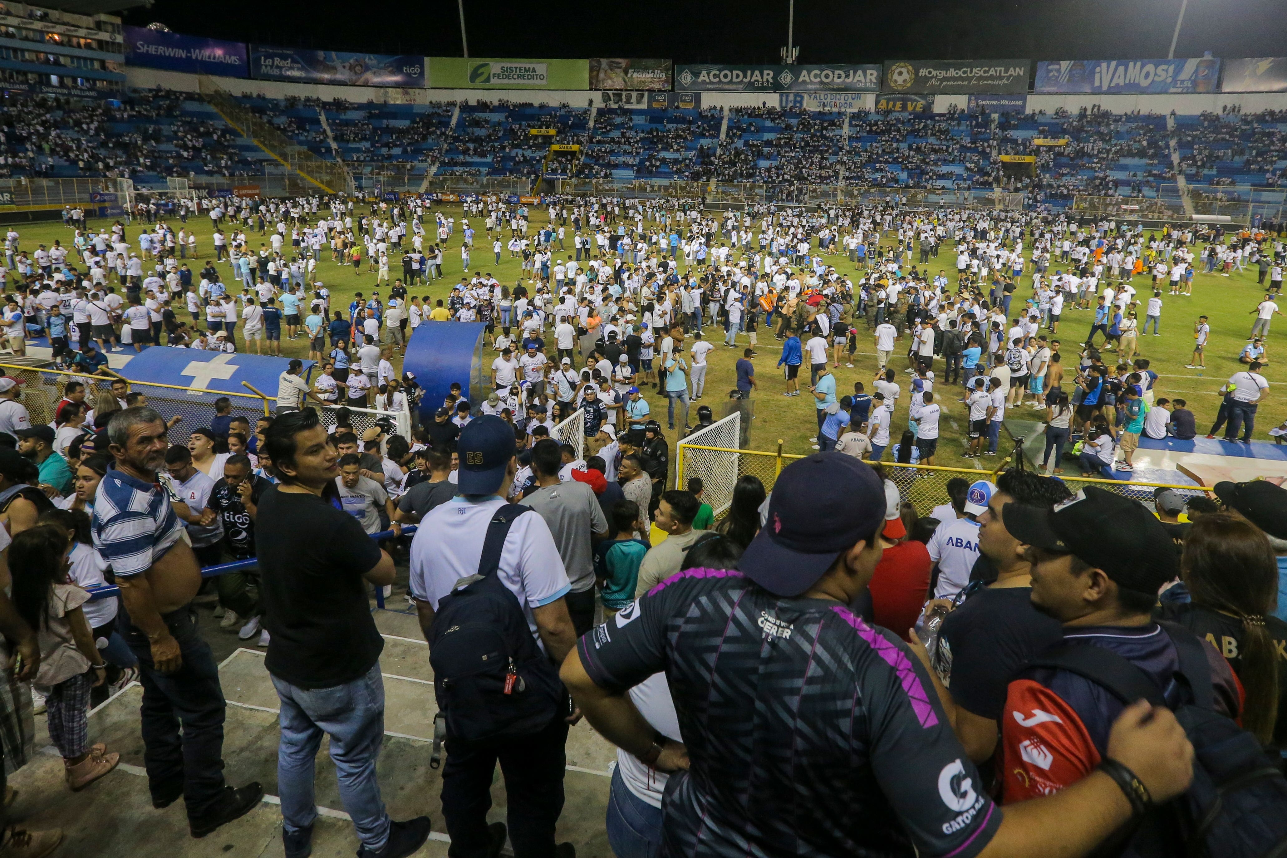 Fans are forced on to the pitch during a crush at the Monumental Stadium in Cuscatlan, El Salvador (Milton Flores/AP)