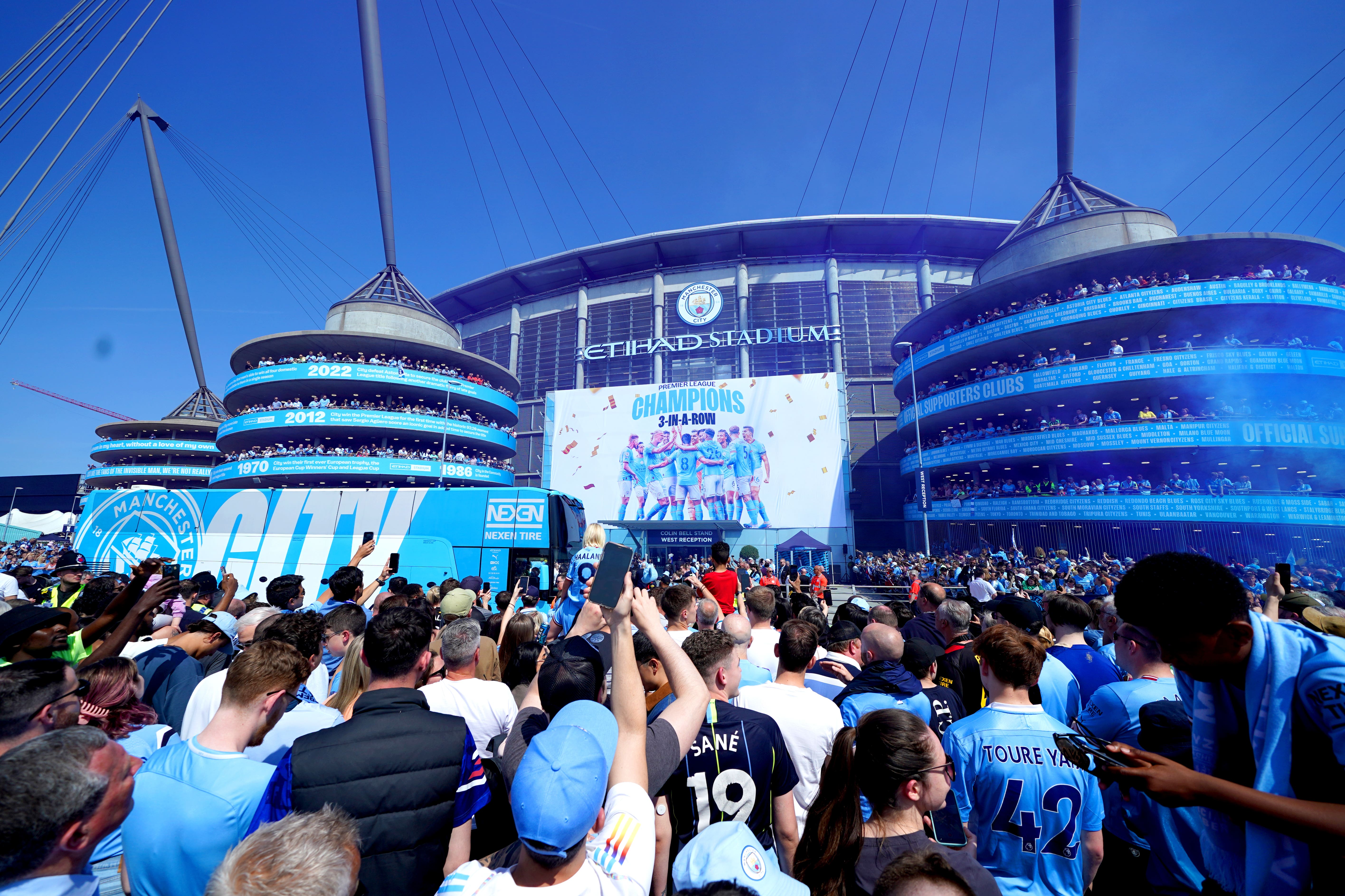 Manchester City fans celebrate as the team bus arrives ahead of the Premier League match against Chelsea at the Etihad Stadium (Martin Rickett/PA)