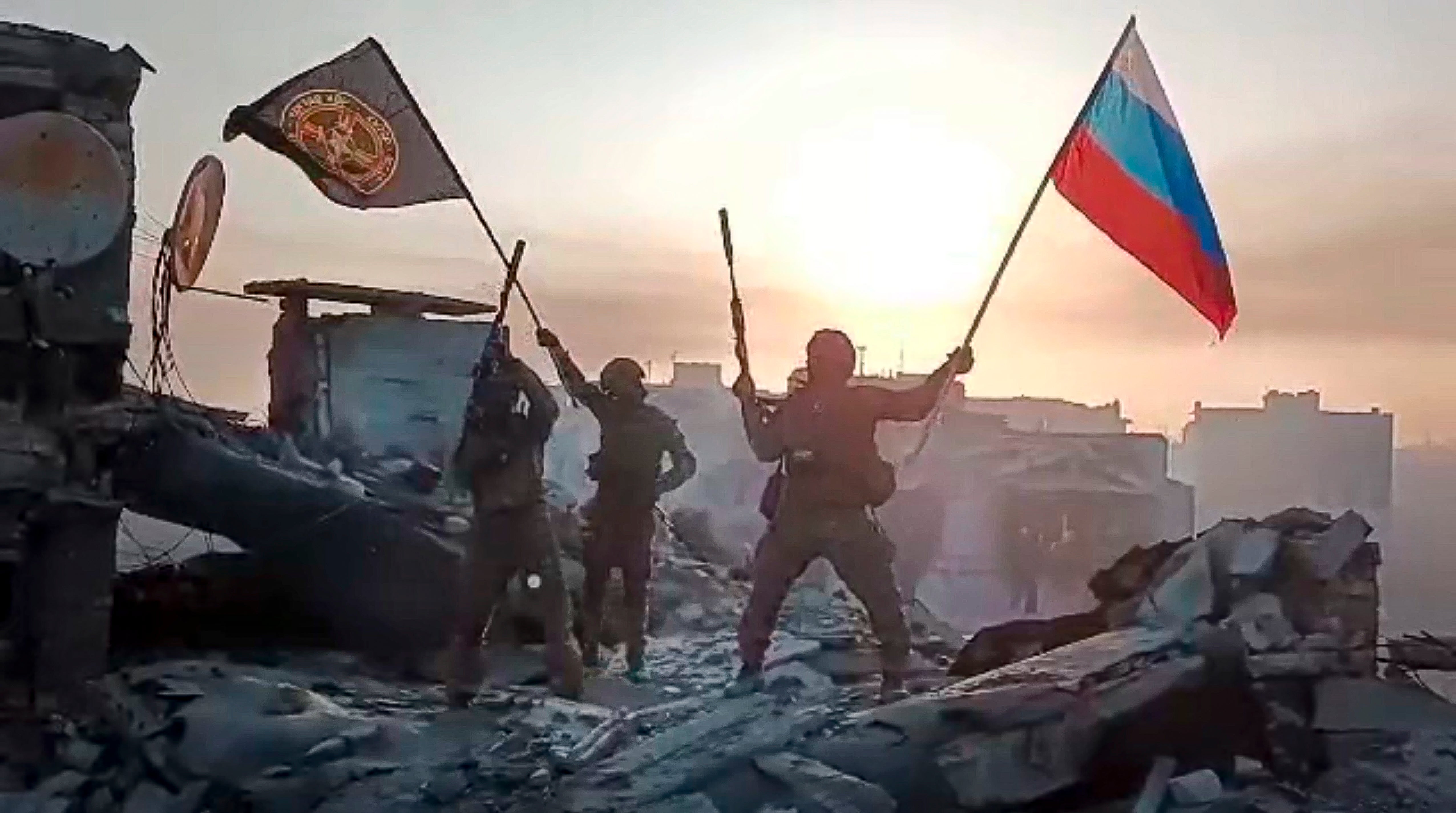 Yevgeny Prigozhin’s Wagner Group military company members wave a Russian national and Wagner flag in Bakhmut